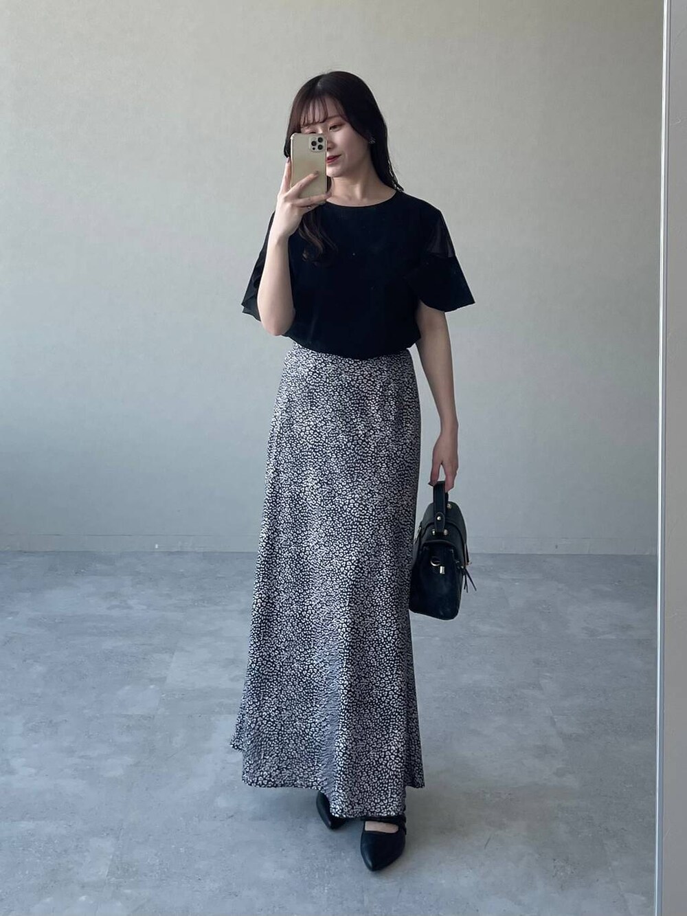 ブラック系のTシャツ/カットソー、ブラック系のスカート、ブラック系のパンプスを着用したレディースの夏コーディネートの4枚目の写真