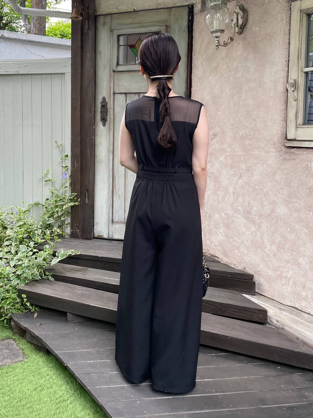 ブラック系のパンプス、ブラック系のショルダーバッグ、ブラック系のつなぎ/オールインワンを着用したレディースの夏コーディネートの2枚目の写真