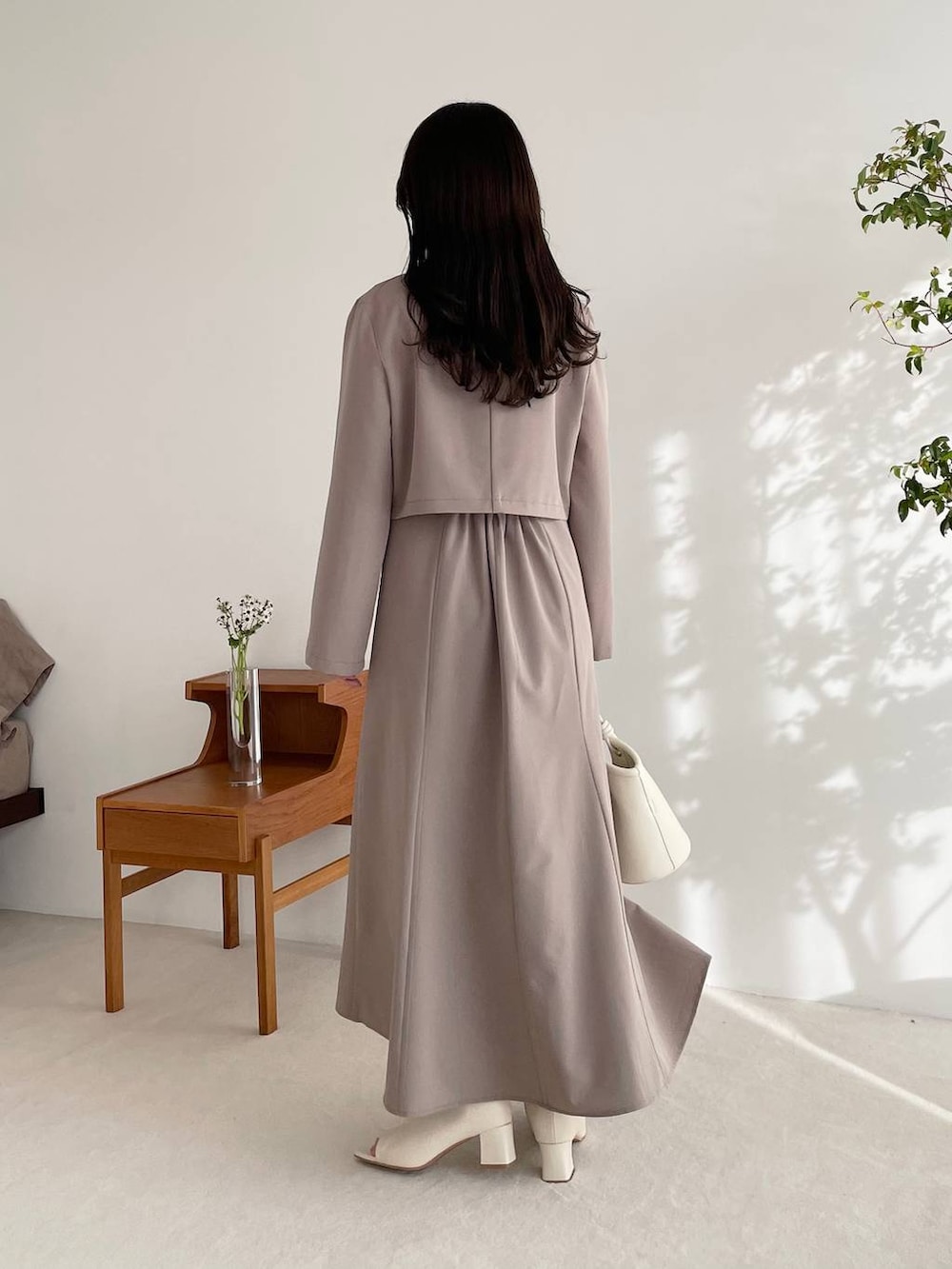 ブラウン系のテーラードジャケット、ブラウン系のワンピース、ホワイト系のブーツを着用したレディースの春コーディネートの2枚目の写真