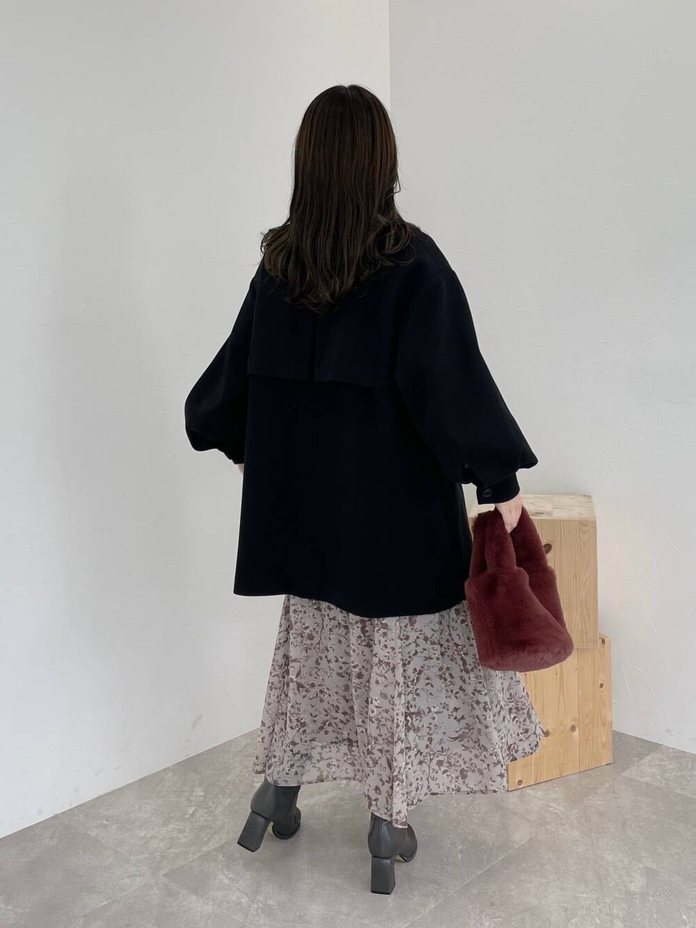 ブラック系のチェスターコート、グレー系のブーツ、ピンク系のハンドバッグを着用したレディースの秋コーディネートの2枚目の写真