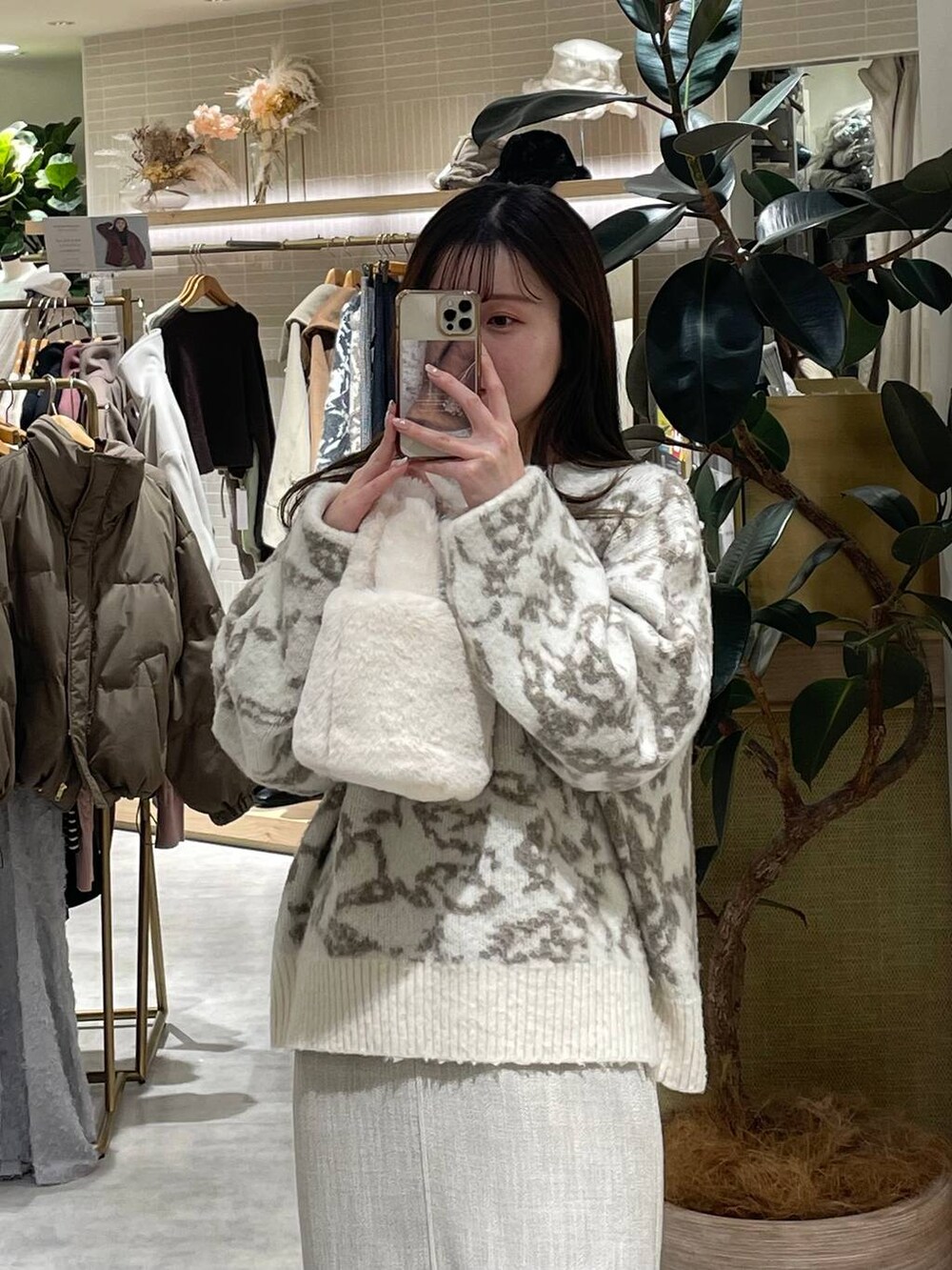 ホワイト系のブーツ、ホワイト系のハンドバッグ、ホワイト系のスカートを着用したレディースの冬コーディネートの7枚目の写真