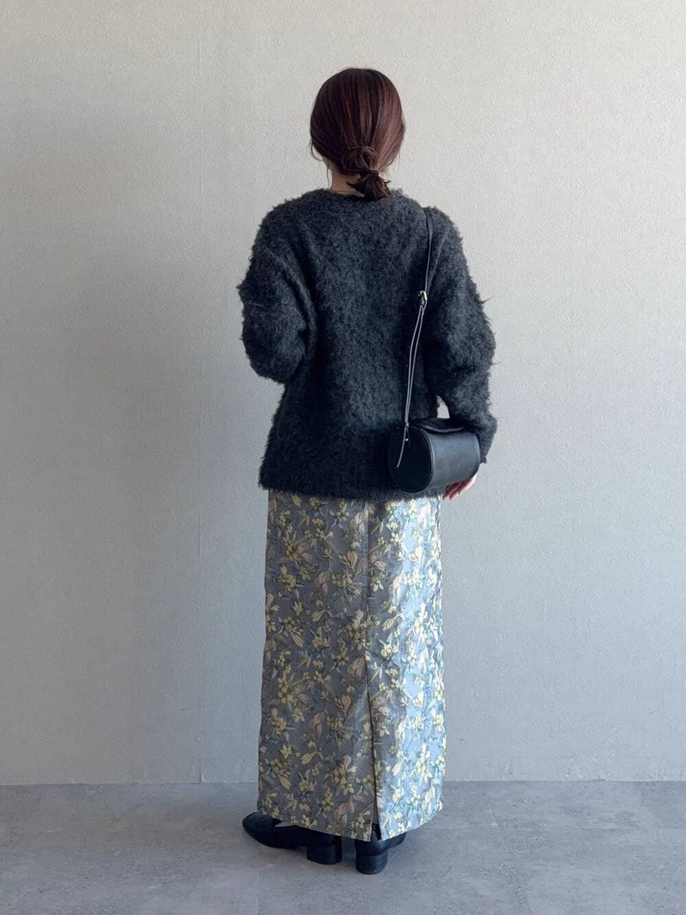 ブラック系のショルダーバッグ、ブラック系のローファー、グレー系のスカートを着用したレディースの冬コーディネートの2枚目の写真