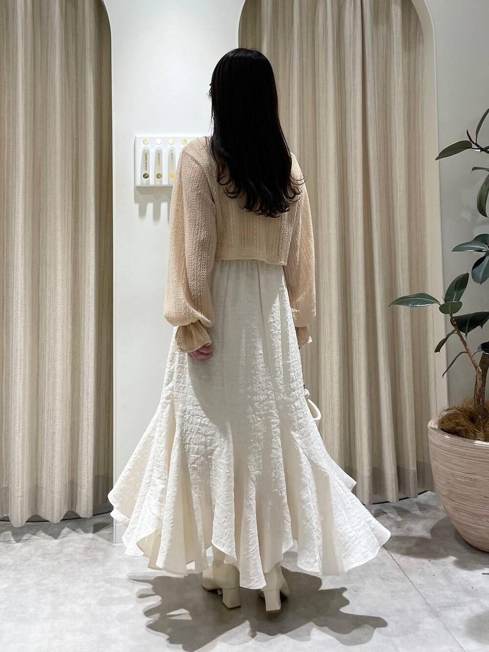 ベージュ系のTシャツ/カットソー、ホワイト系のハンドバッグ、ホワイト系のブーツを着用したレディースの春コーディネートの5枚目の写真