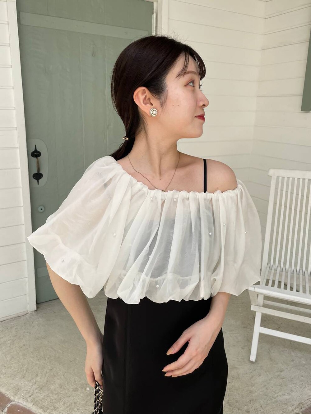 ブラック系のパンプス、ブラック系のショルダーバッグ、ブラック系のドレスを着用したレディースの夏コーディネートの4枚目の写真