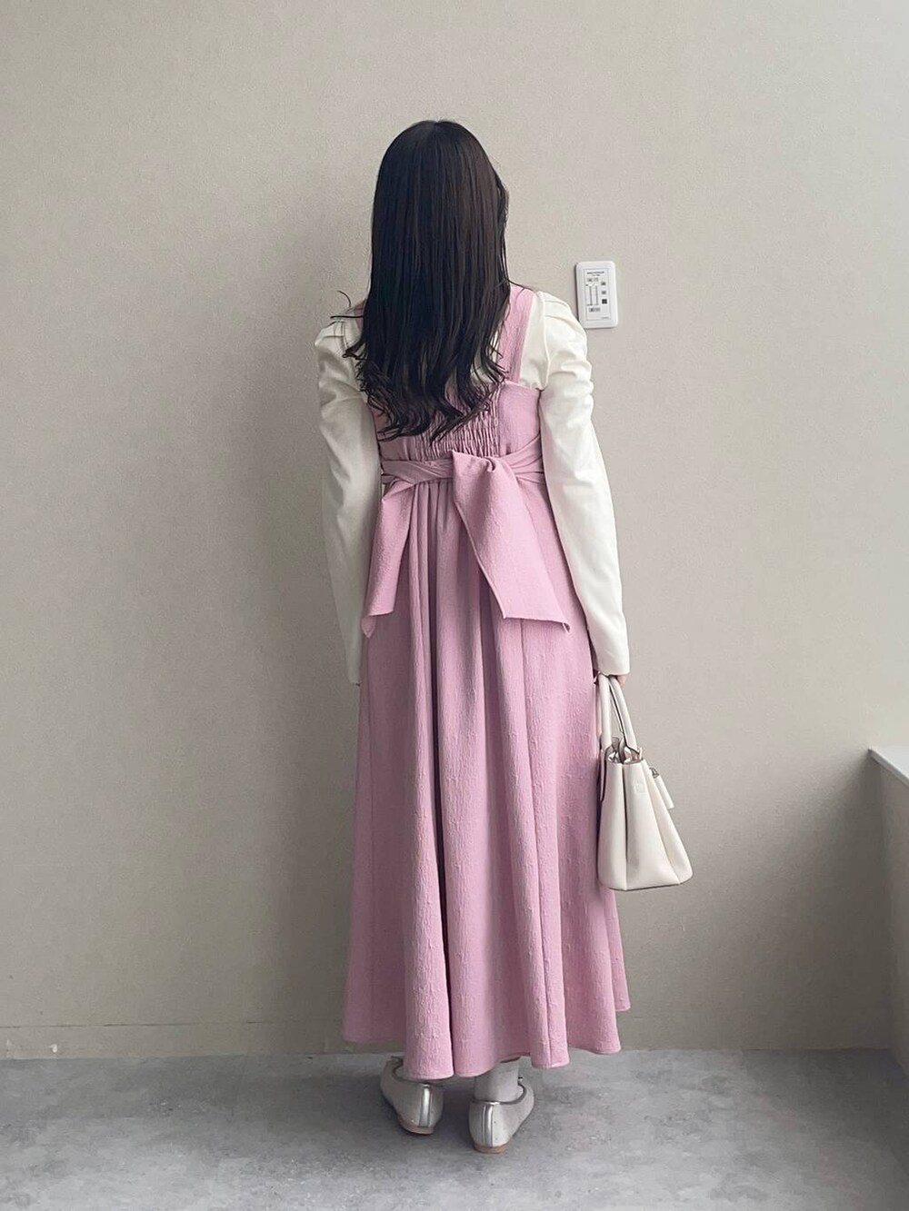 ホワイト系のショルダーバッグ、シルバー系のバレエシューズ、ピンク系のワンピースを着用したレディースの春コーディネートの2枚目の写真