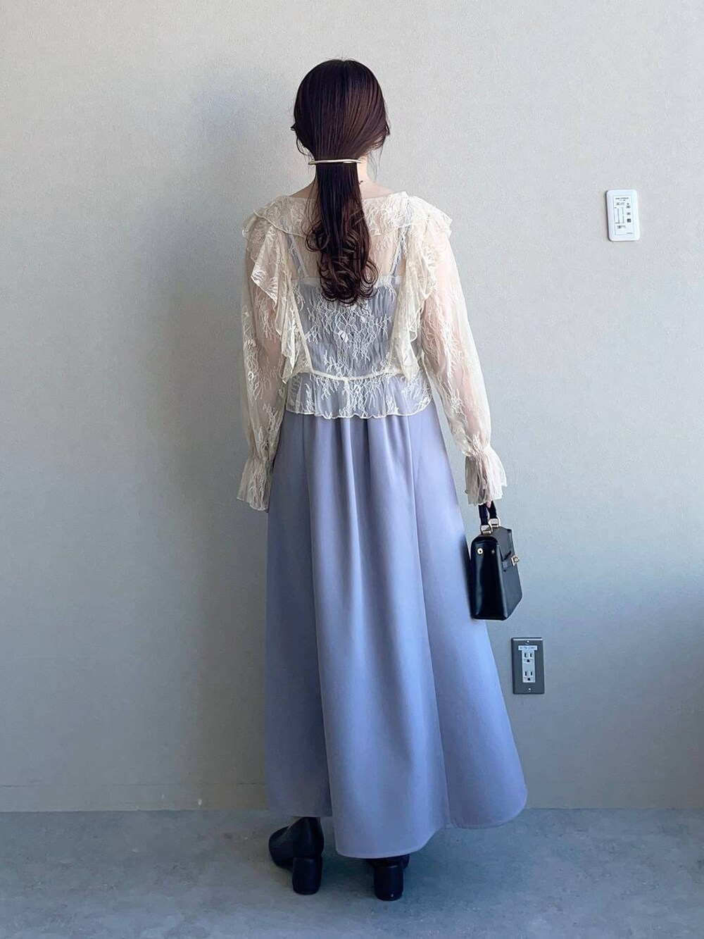 ブラック系のパンプス、グレー系のドレスを着用したレディースの冬コーディネートの2枚目の写真