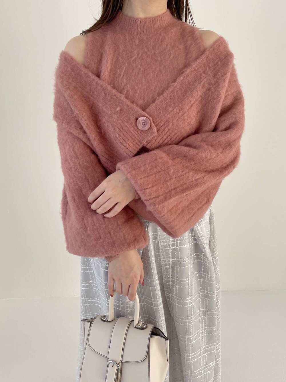 ホワイト系のハンドバッグ、ホワイト系のブーツ、ピンク系のカーディガン/ボレロを着用したレディースの秋コーディネートの3枚目の写真