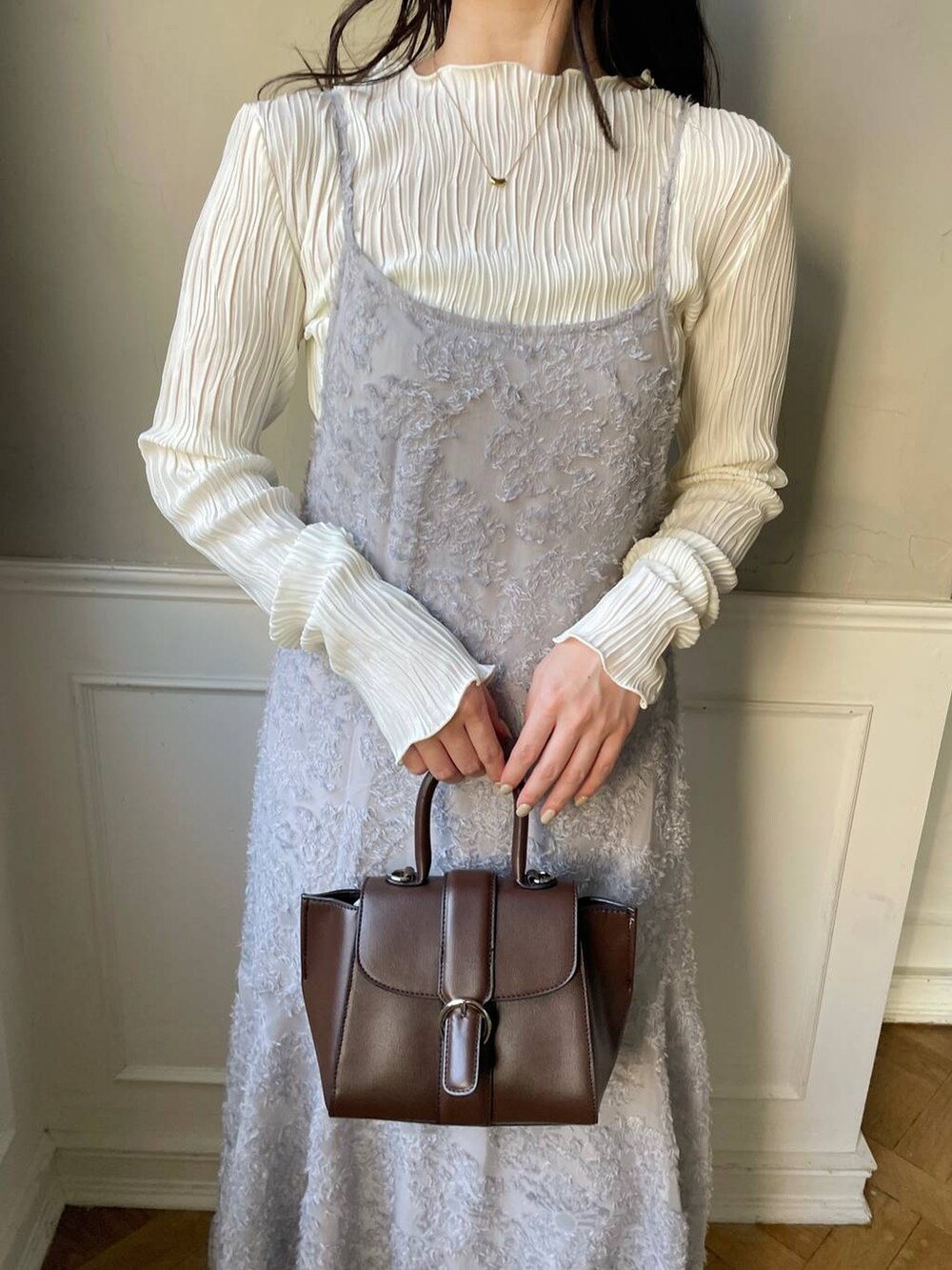 ブラウン系のハンドバッグ、ホワイト系のブーツ、ホワイト系のTシャツ/カットソーを着用したレディースの秋コーディネートの6枚目の写真