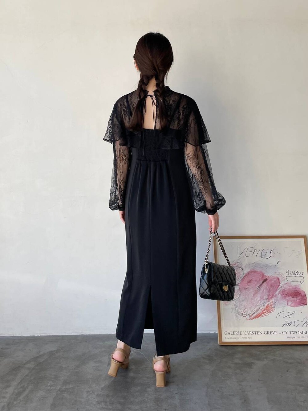 ブラック系のドレス、ブラック系のショルダーバッグ、ベージュ系のパンプスを着用したレディースの冬コーディネートの2枚目の写真