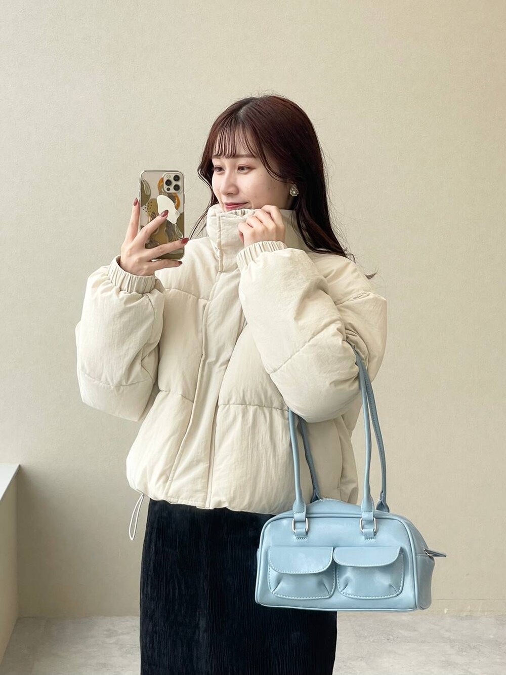 ホワイト系のブルゾン、ホワイト系のブーツ、ブラック系のスカートを着用したレディースの秋コーディネートの3枚目の写真