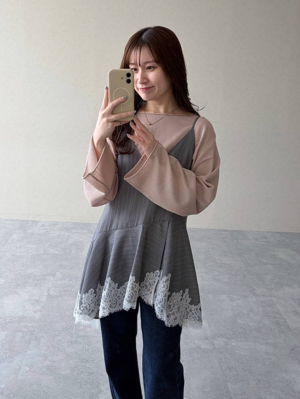 ベージュ系のニット/セーター、ブルー系のデニムパンツ、ブラック系のサンダルを着用したレディースの春コーディネートの3枚目の写真