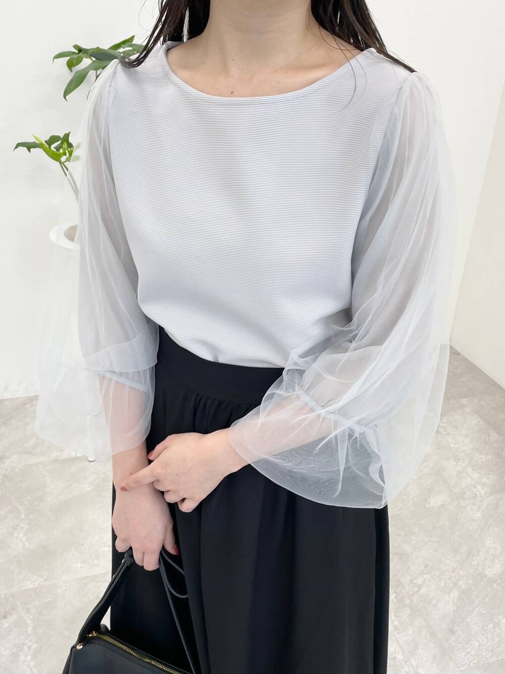 ブラック系のショルダーバッグ、ホワイト系のサンダル、ブルー系のTシャツ/カットソーを着用したレディースの夏コーディネートの3枚目の写真