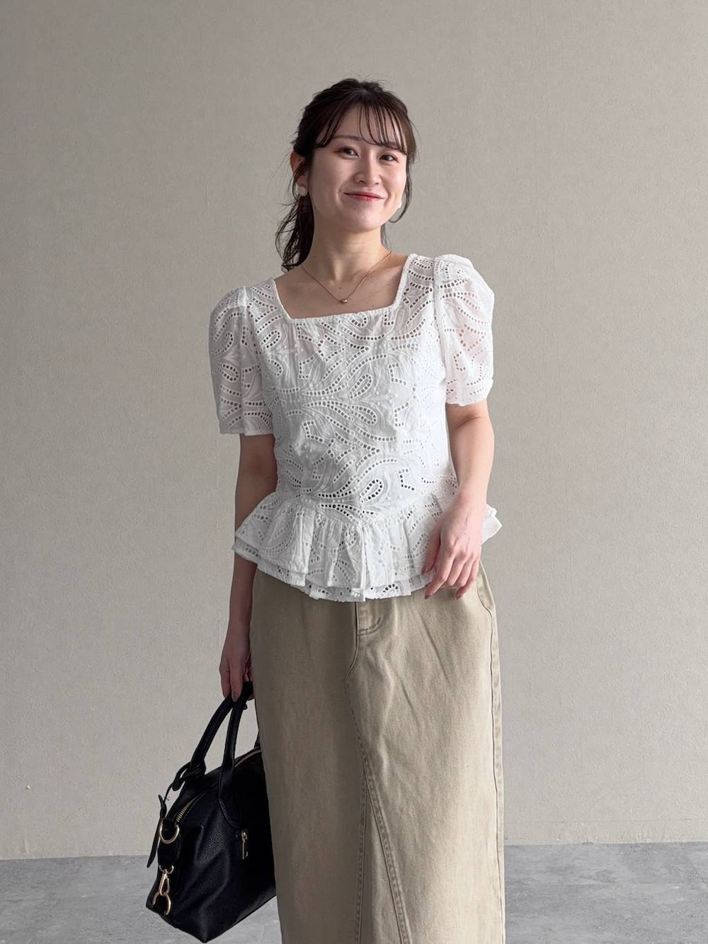 ブラック系のボストンバッグ、ブラック系のサンダル、ホワイト系のシャツ/ブラウスを着用したレディースの春コーディネートの3枚目の写真