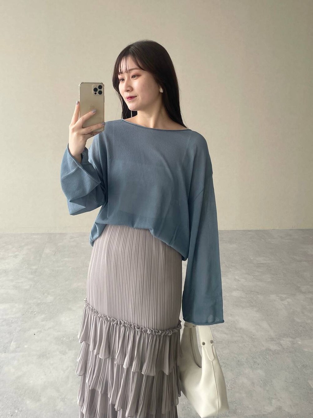 ブルー系のニット/セーター、シルバー系のバレエシューズ、グレー系のスカートを着用したレディースの春コーディネートの3枚目の写真