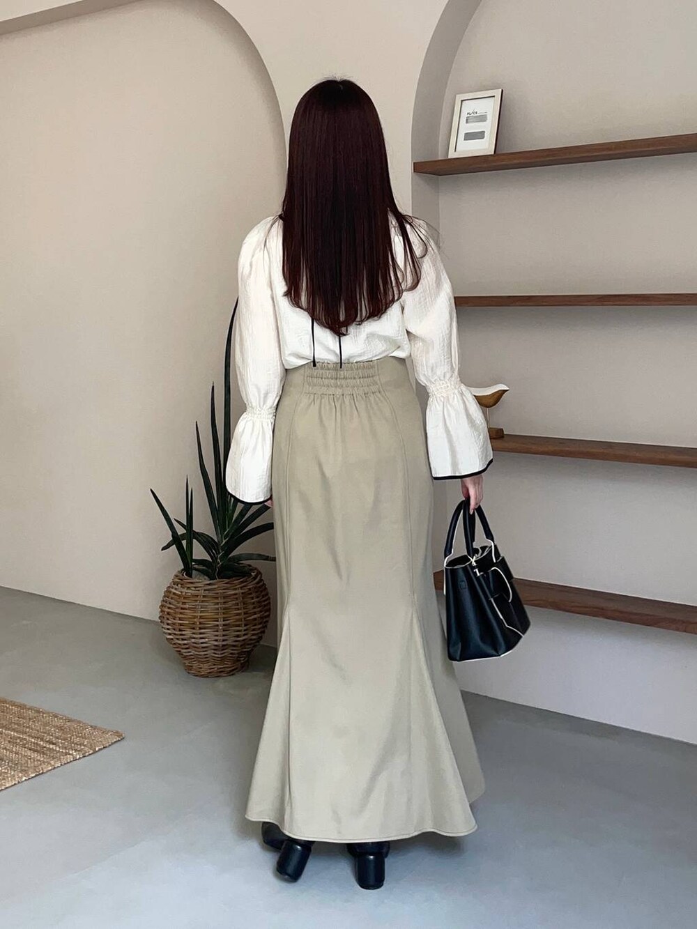 ブラック系のショルダーバッグ、ホワイト系のシャツ/ブラウス、ブラック系のパンプスを着用したレディースの春コーディネートの2枚目の写真