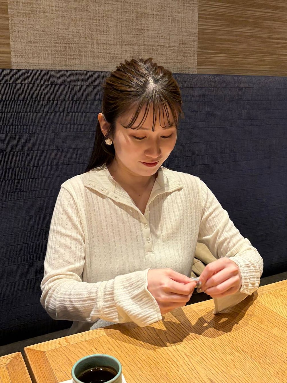 ホワイト系のスカート、ブラウン系のボストンバッグ、ベージュ系のトレンチコートを着用したレディースの冬コーディネートの5枚目の写真