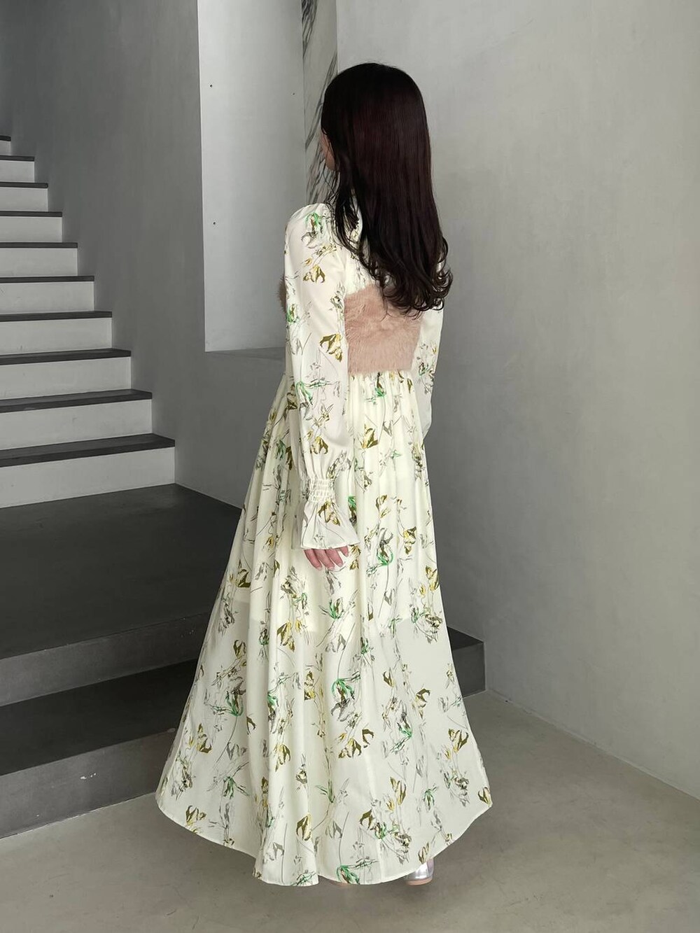 ホワイト系のショルダーバッグ、イエロー系のワンピースを着用したレディースの冬コーディネートの2枚目の写真