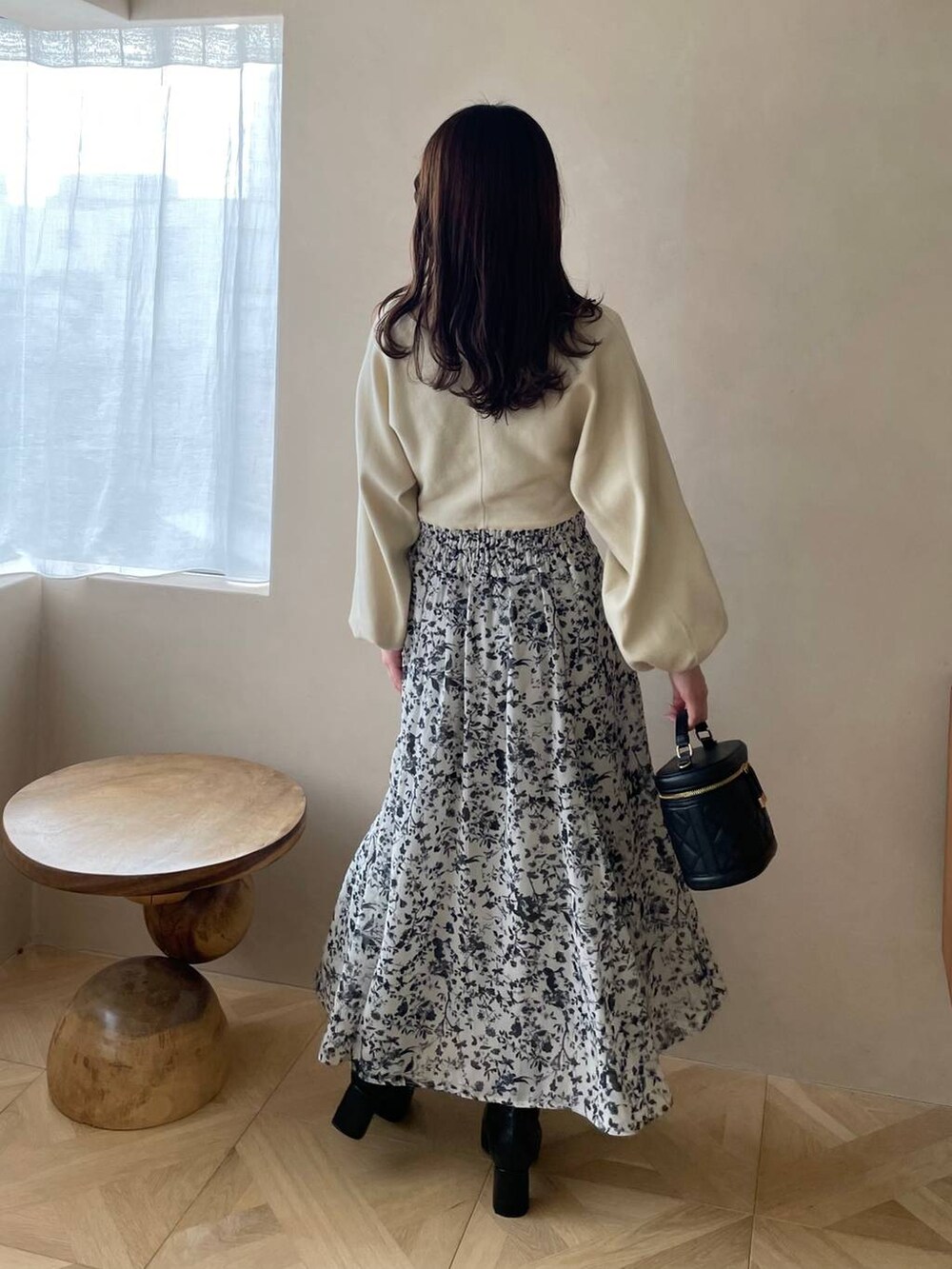 ブラック系のブーツ、ブラック系のショルダーバッグ、ホワイト系のワンピースを着用したレディースの冬コーディネートの2枚目の写真