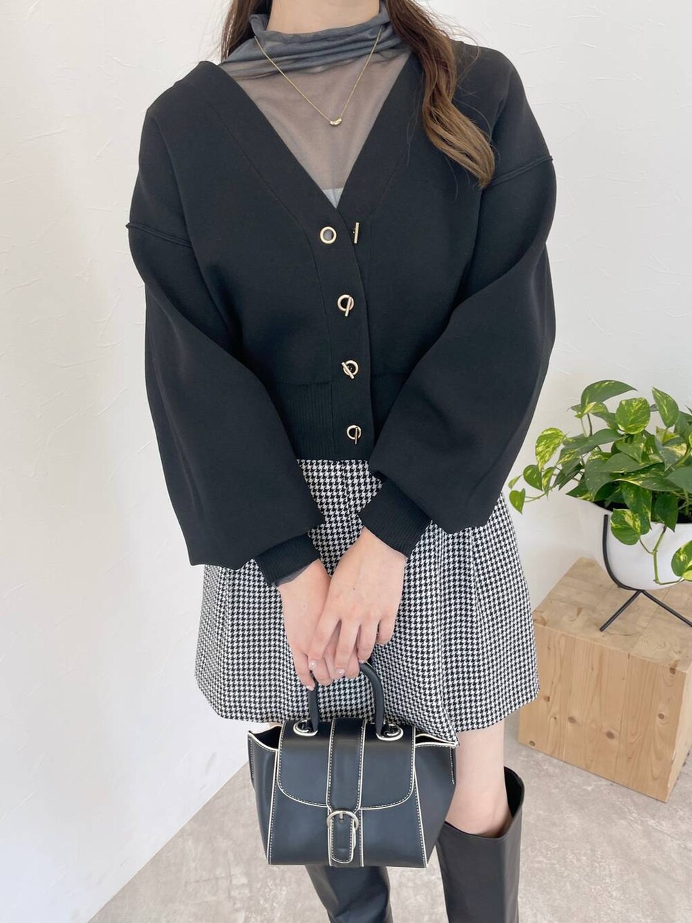 ブラック系のハンドバッグ、ブラック系のブーツ、グレー系のTシャツ/カットソーを着用したレディースの秋コーディネートの3枚目の写真