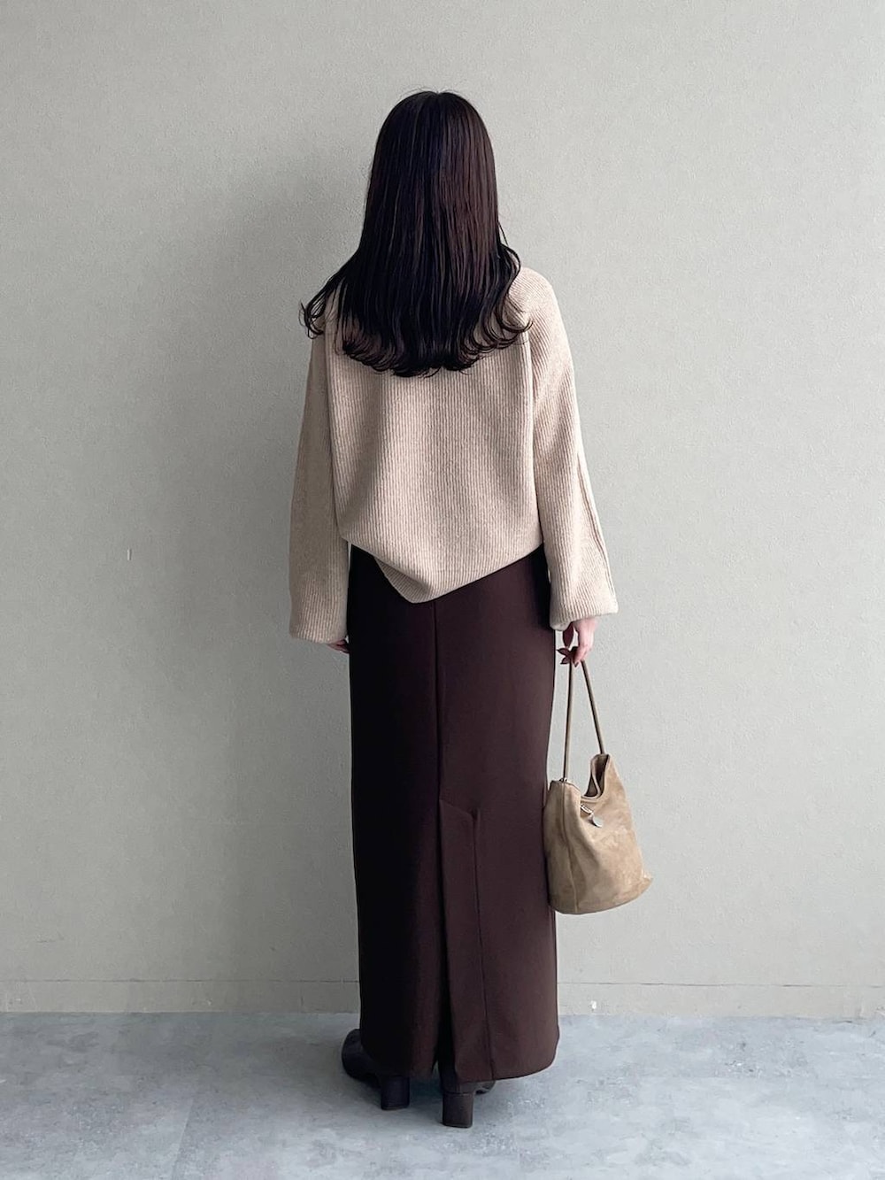 ベージュ系のニット/セーター、ベージュ系のマウンテンパーカー、ブラウン系のスカートを着用したレディースの秋コーディネートの4枚目の写真