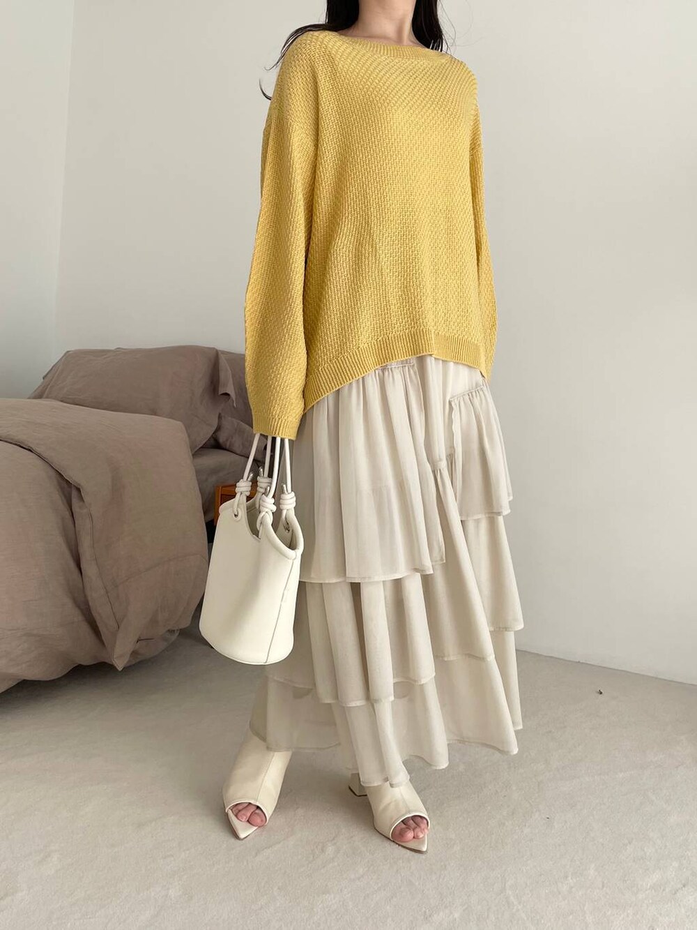 ホワイト系のスカート、イエロー系のTシャツ/カットソー、ホワイト系のブーツを着用したレディースの春コーディネートの4枚目の写真