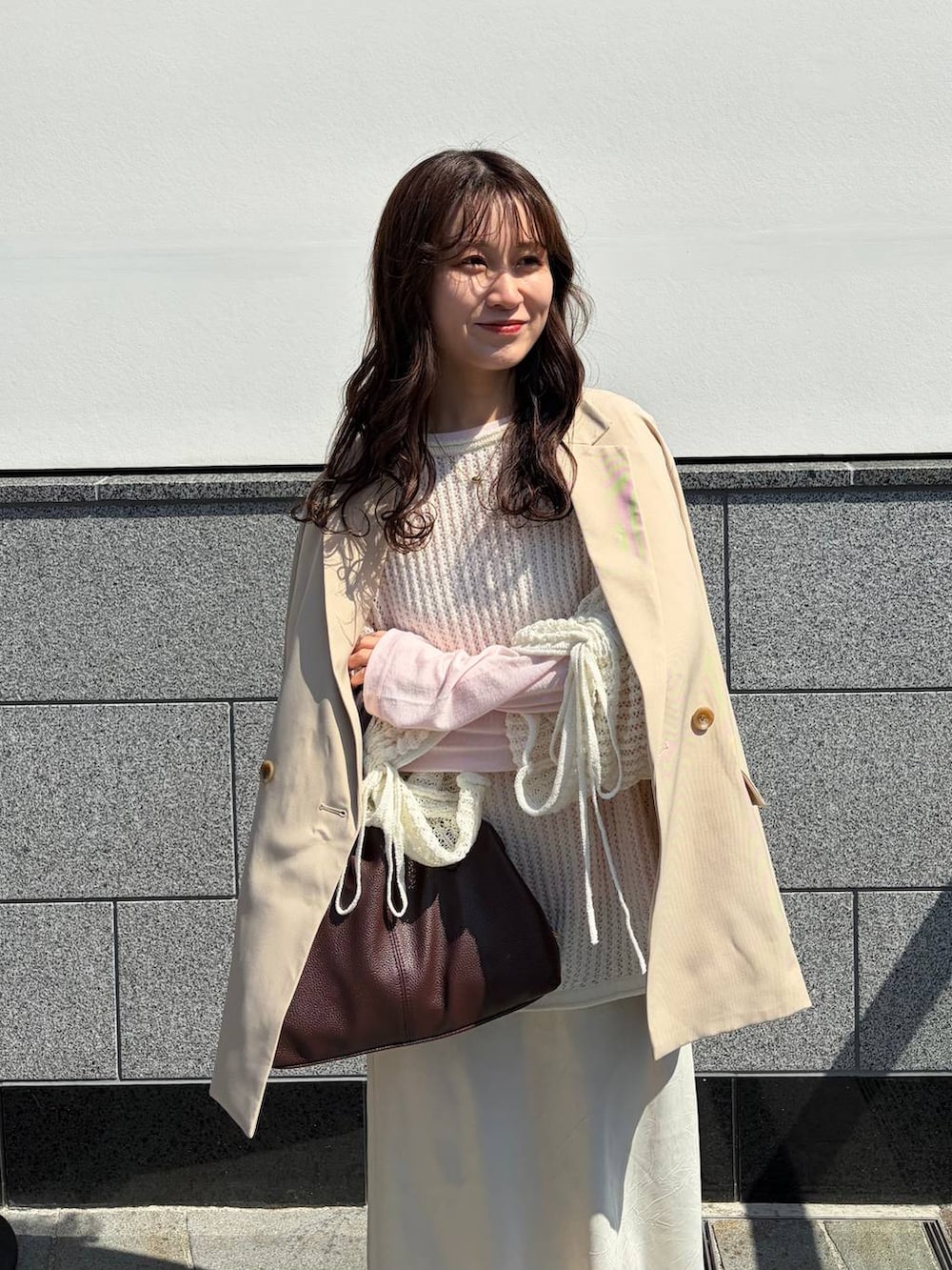 ホワイト系のスカート、ピンク系のTシャツ/カットソー、ブラウン系のボストンバッグを着用したレディースの春コーディネートの3枚目の写真