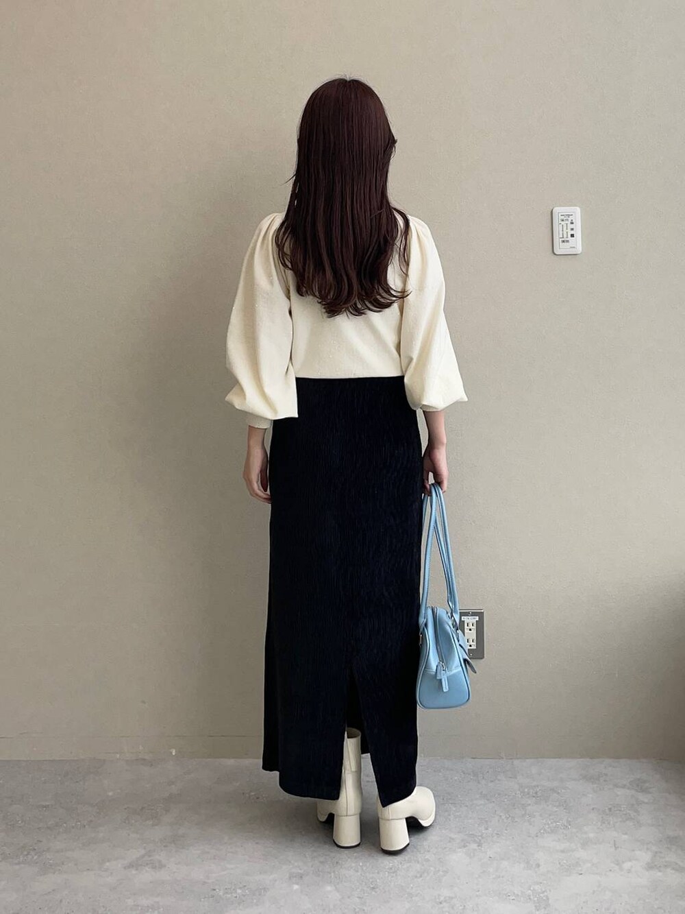 ホワイト系のブルゾン、ホワイト系のブーツ、ブラック系のスカートを着用したレディースの秋コーディネートの8枚目の写真