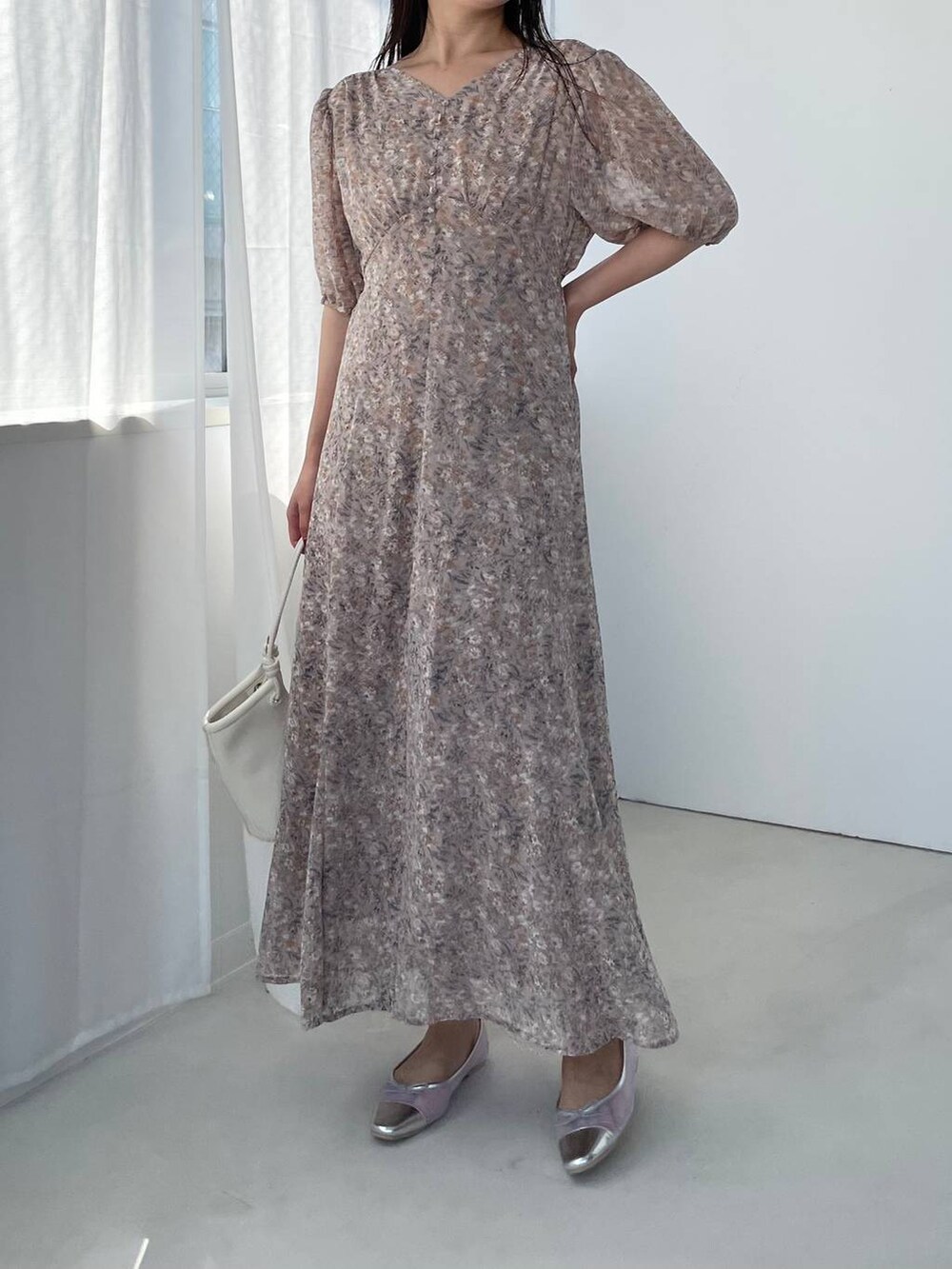 シルバー系のバレエシューズ、ホワイト系のハンドバッグ、ピンク系のワンピースを着用したレディースの夏コーディネートの4枚目の写真