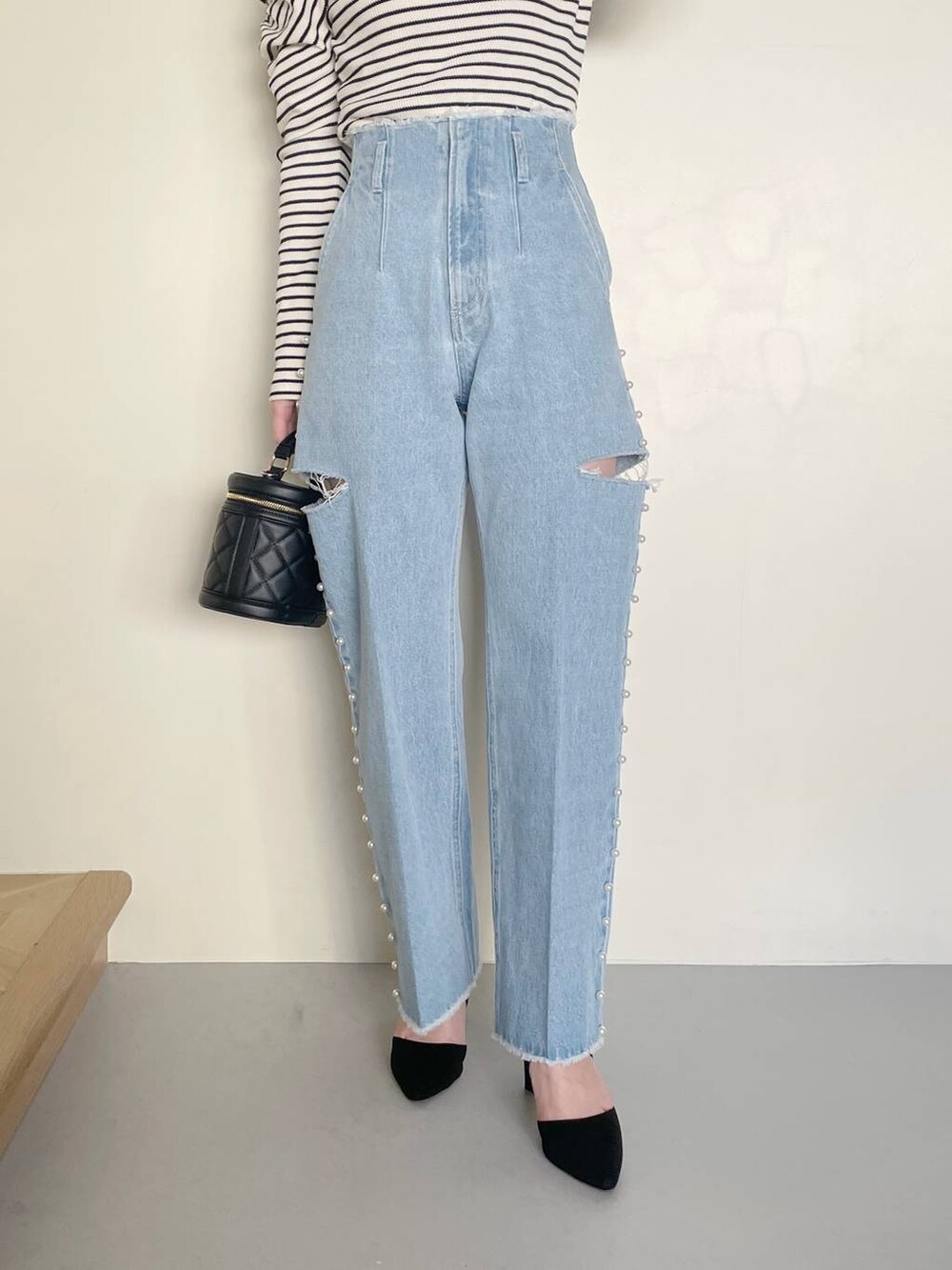 ブラック系のショルダーバッグ、ブルー系のデニムパンツ、ホワイト系のTシャツ/カットソーを着用したレディースの冬コーディネートの4枚目の写真