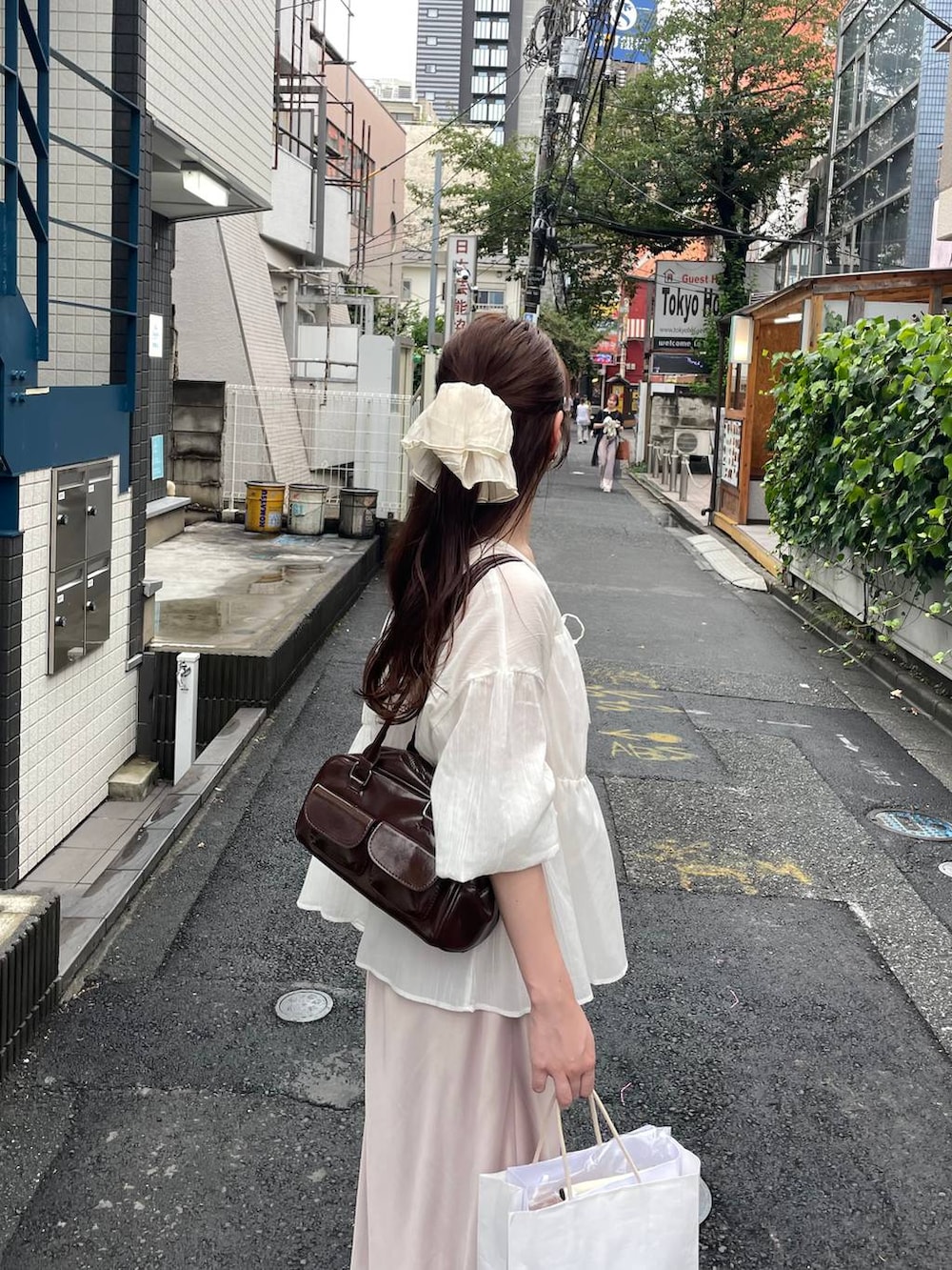 ベージュ系のスカート、ホワイト系のシャツ/ブラウス、ベージュ系のシュシュを着用したレディースの夏コーディネートの4枚目の写真