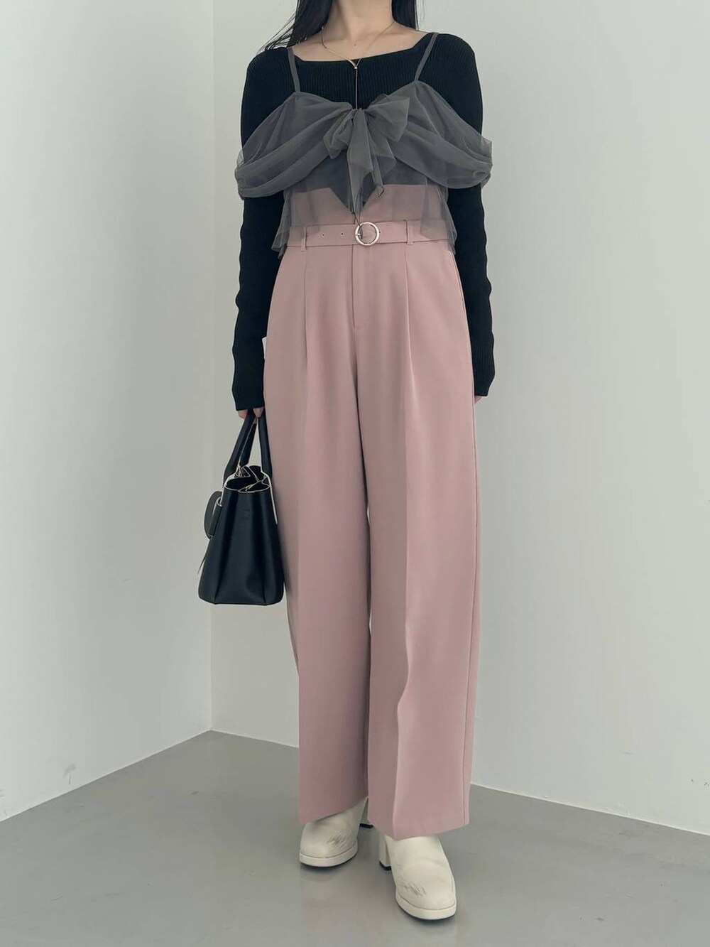 ホワイト系のブーツ、ブラック系のショルダーバッグ、ピンク系のその他パンツを着用したレディースの冬コーディネートの4枚目の写真