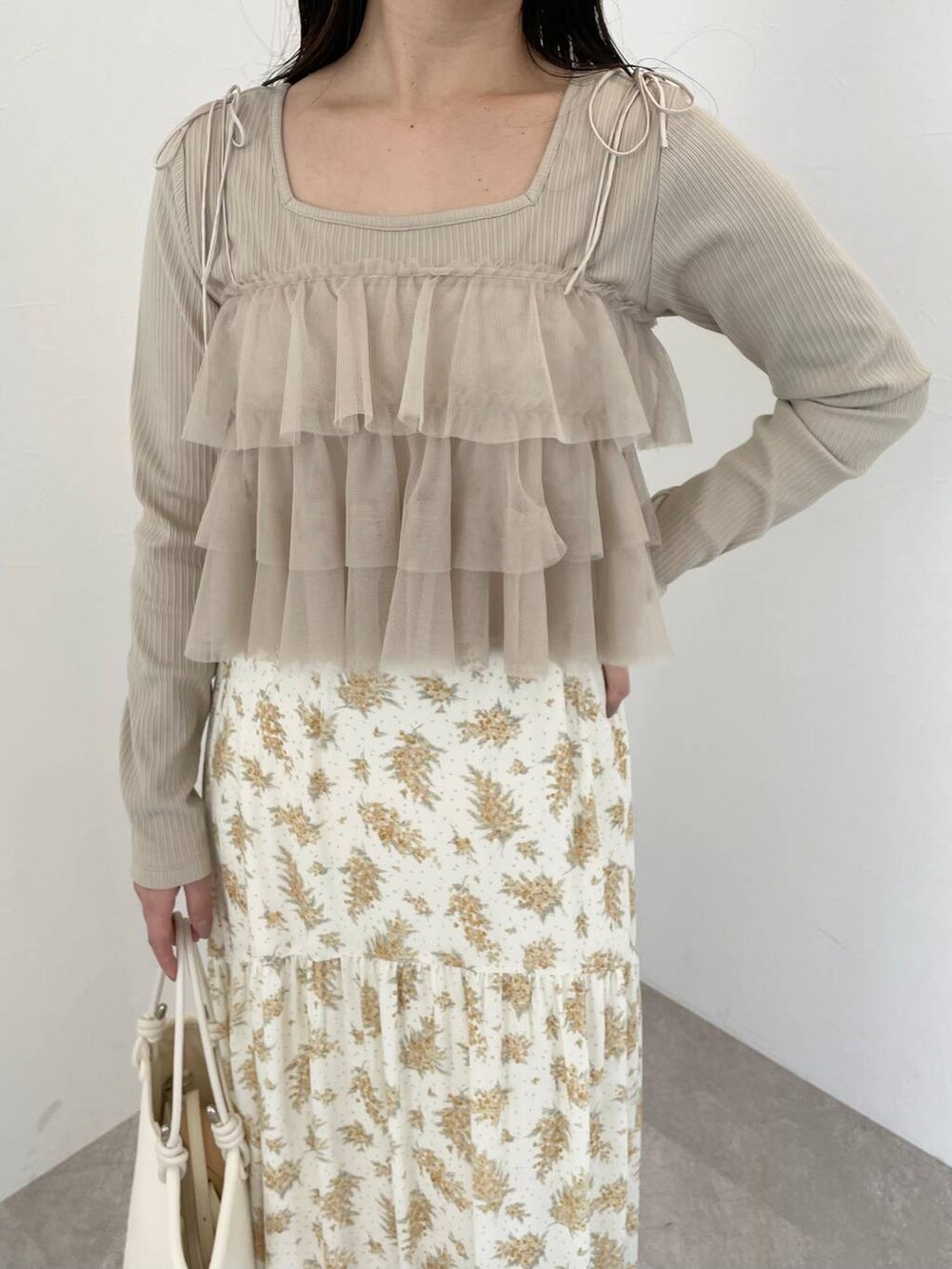 イエロー系のスカート、ベージュ系のシャツ/ブラウス、ホワイト系のブーツを着用したレディースの春コーディネートの3枚目の写真