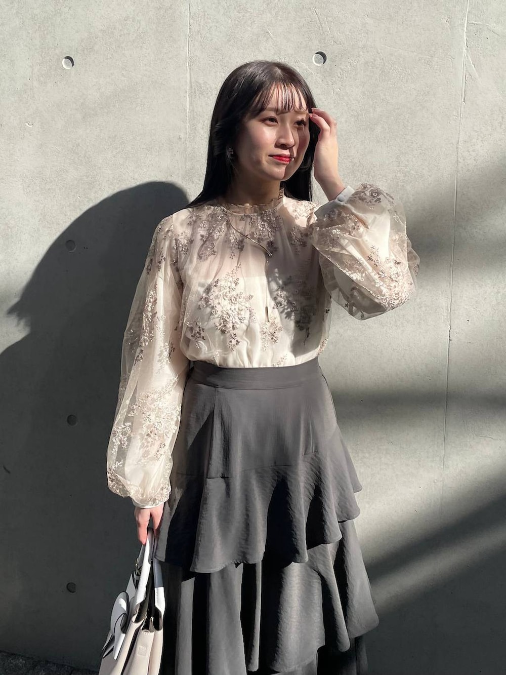 ホワイト系のシャツ/ブラウス、グレー系のスカート、ベージュ系のショルダーバッグを着用したレディースの春コーディネートの3枚目の写真