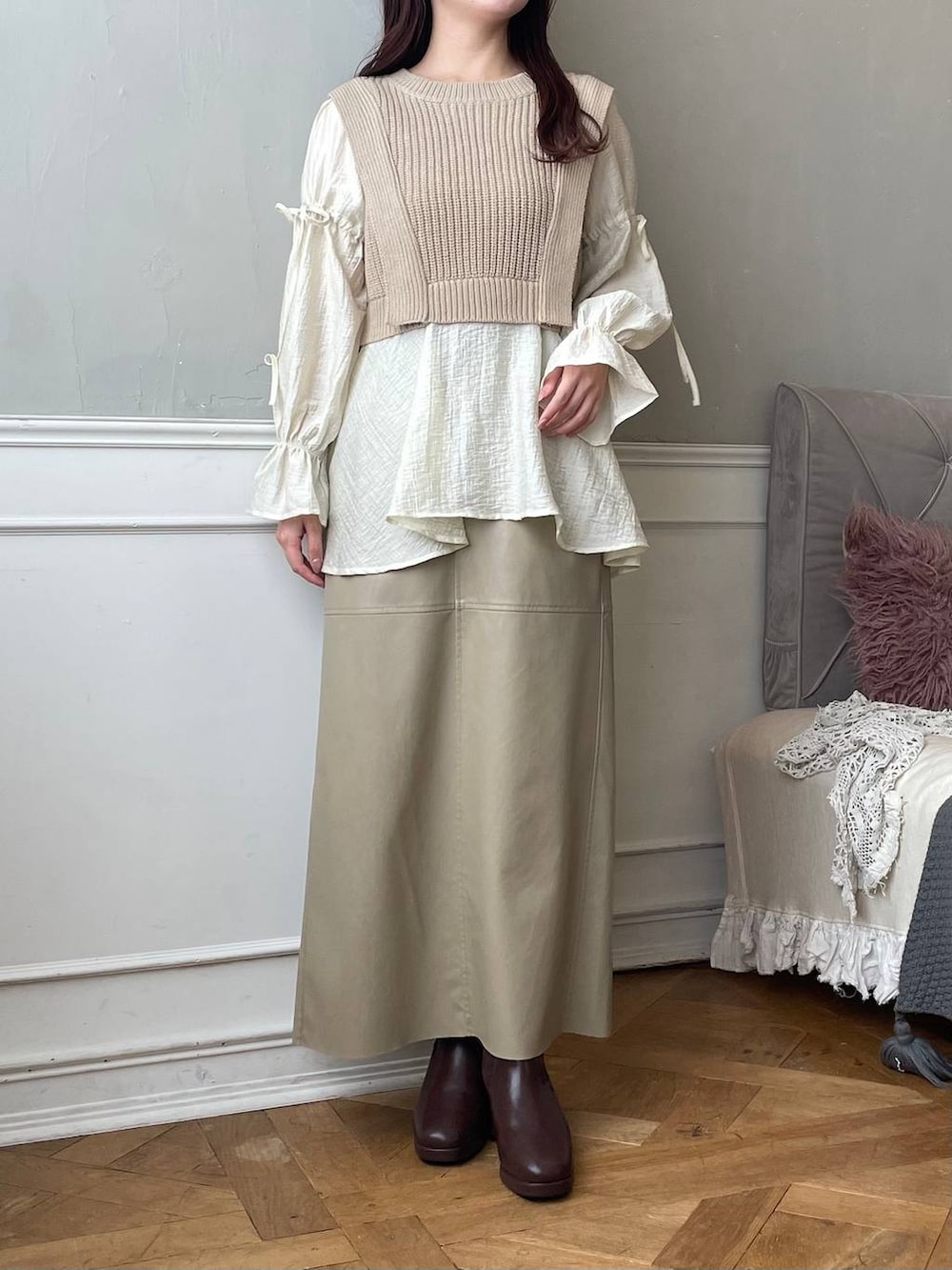 ブラウン系のブーツ、ホワイト系のショルダーバッグ、ベージュ系のスカートを着用したレディースの冬コーディネートの4枚目の写真