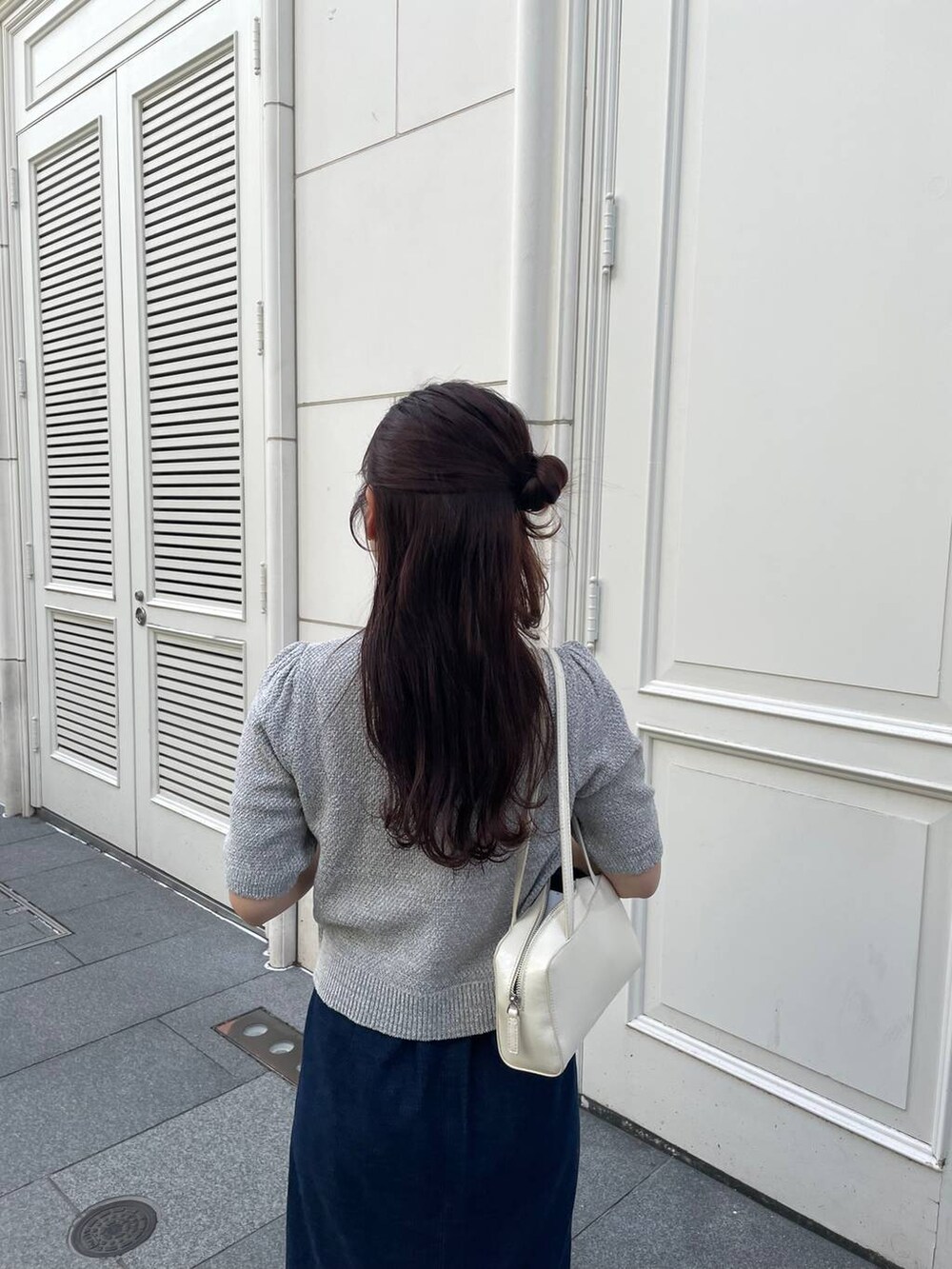 ベージュ系のパンプス、ブルー系のスカート、グレー系のカーディガン/ボレロを着用したレディースの春コーディネートの5枚目の写真