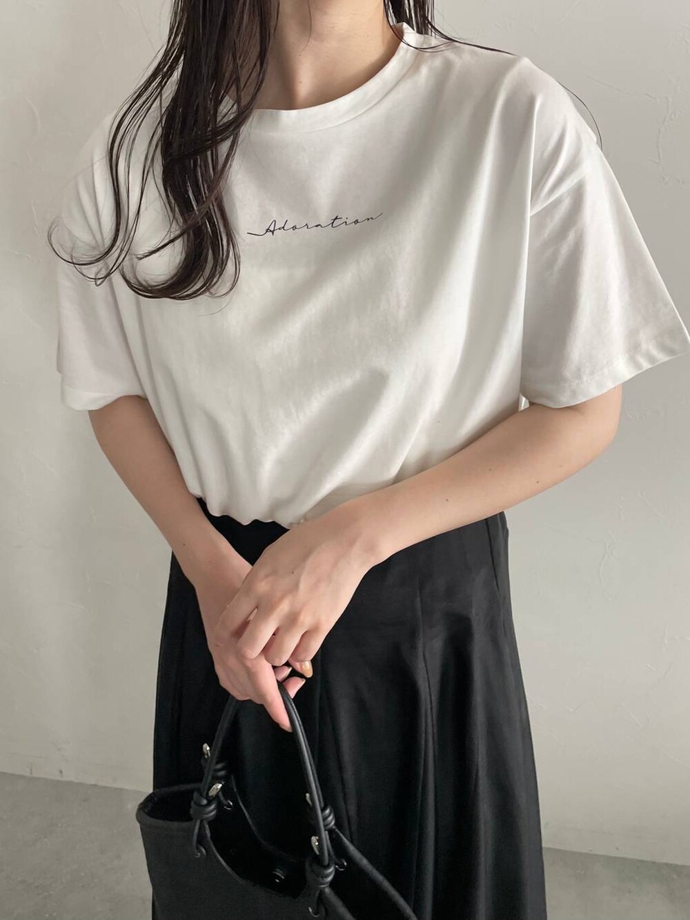 ブラック系のハンドバッグ、ホワイト系のサンダル、ブラック系のスカートを着用したレディースの春コーディネートの4枚目の写真