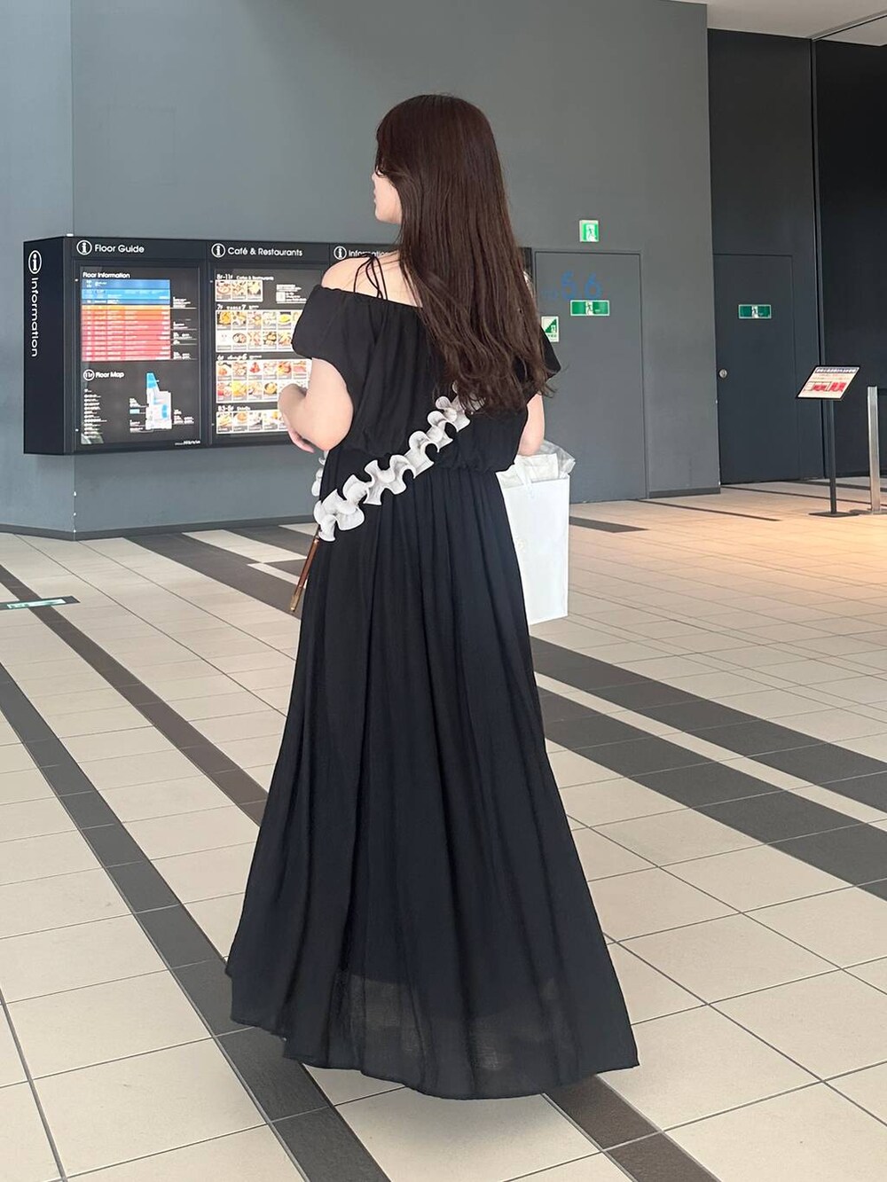 ブラック系のワンピース、グレー系のスマホグッズを着用したレディースの夏コーディネートの2枚目の写真