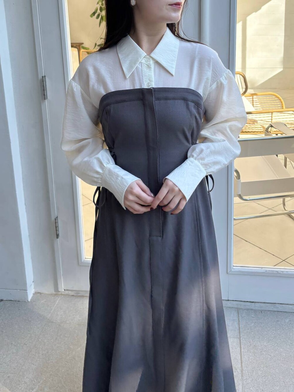 ホワイト系のブーツ、ホワイト系のショルダーバッグ、グレー系のワンピースを着用したレディースの冬コーディネートの3枚目の写真