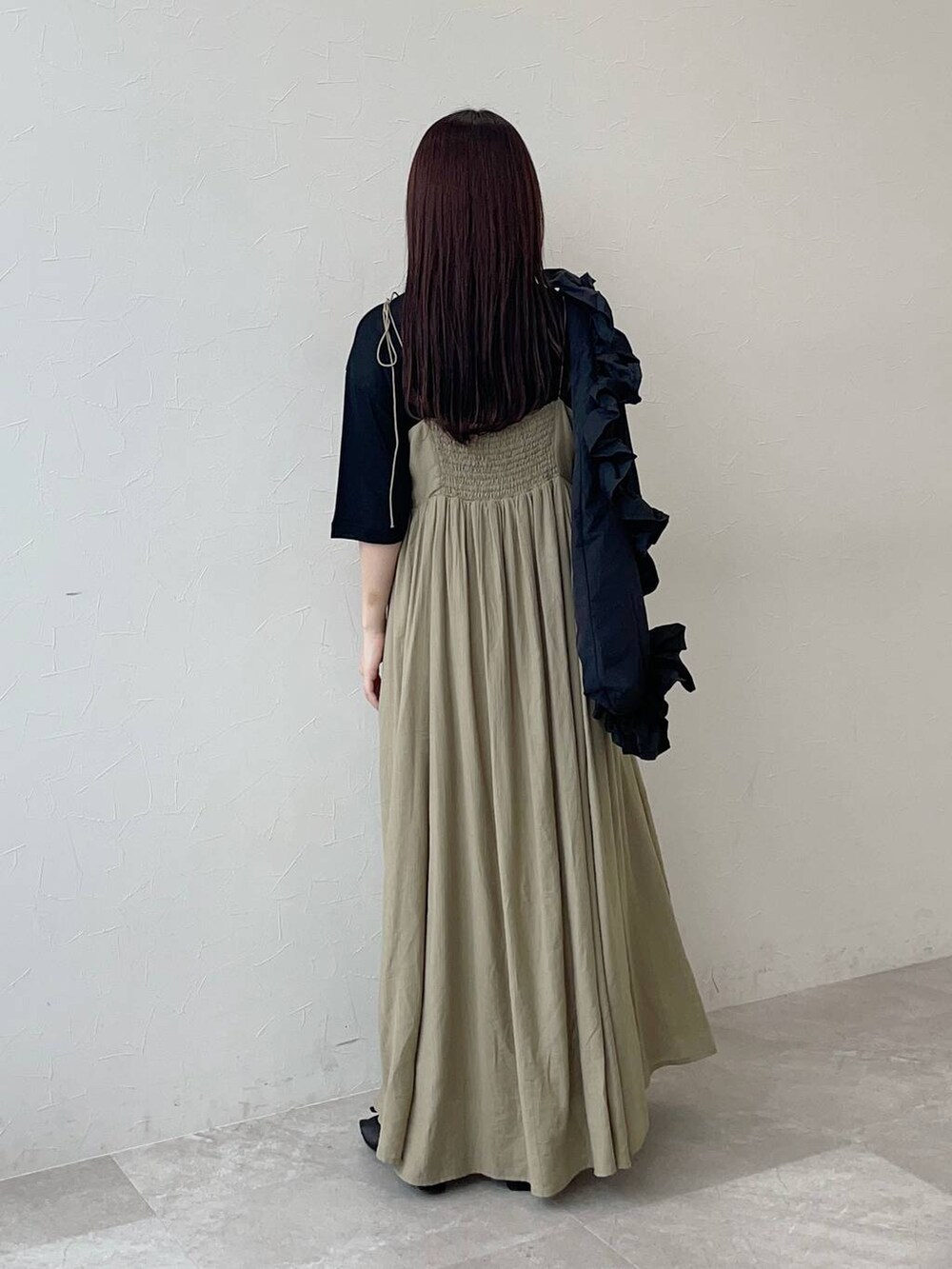 ブラック系のサンダル、ベージュ系のワンピース、ブラック系のTシャツ/カットソーを着用したレディースの春コーディネートの2枚目の写真