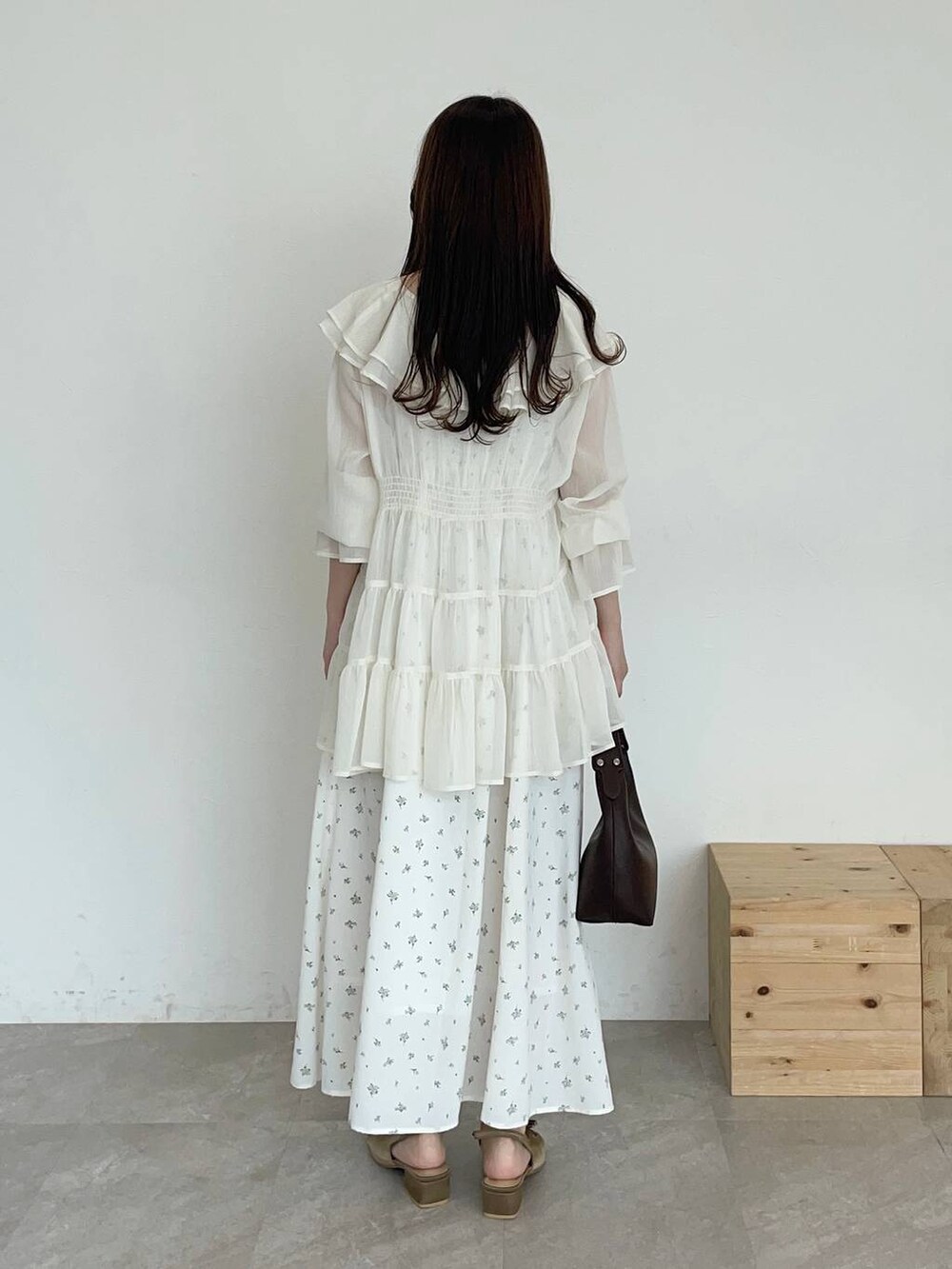 ブラウン系のサンダル、ブラウン系のショルダーバッグ、ホワイト系のシャツ/ブラウスを着用したレディースの夏コーディネートの2枚目の写真