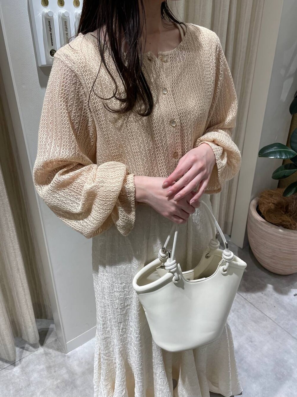 ベージュ系のTシャツ/カットソー、ホワイト系のハンドバッグ、ホワイト系のブーツを着用したレディースの春コーディネートの6枚目の写真