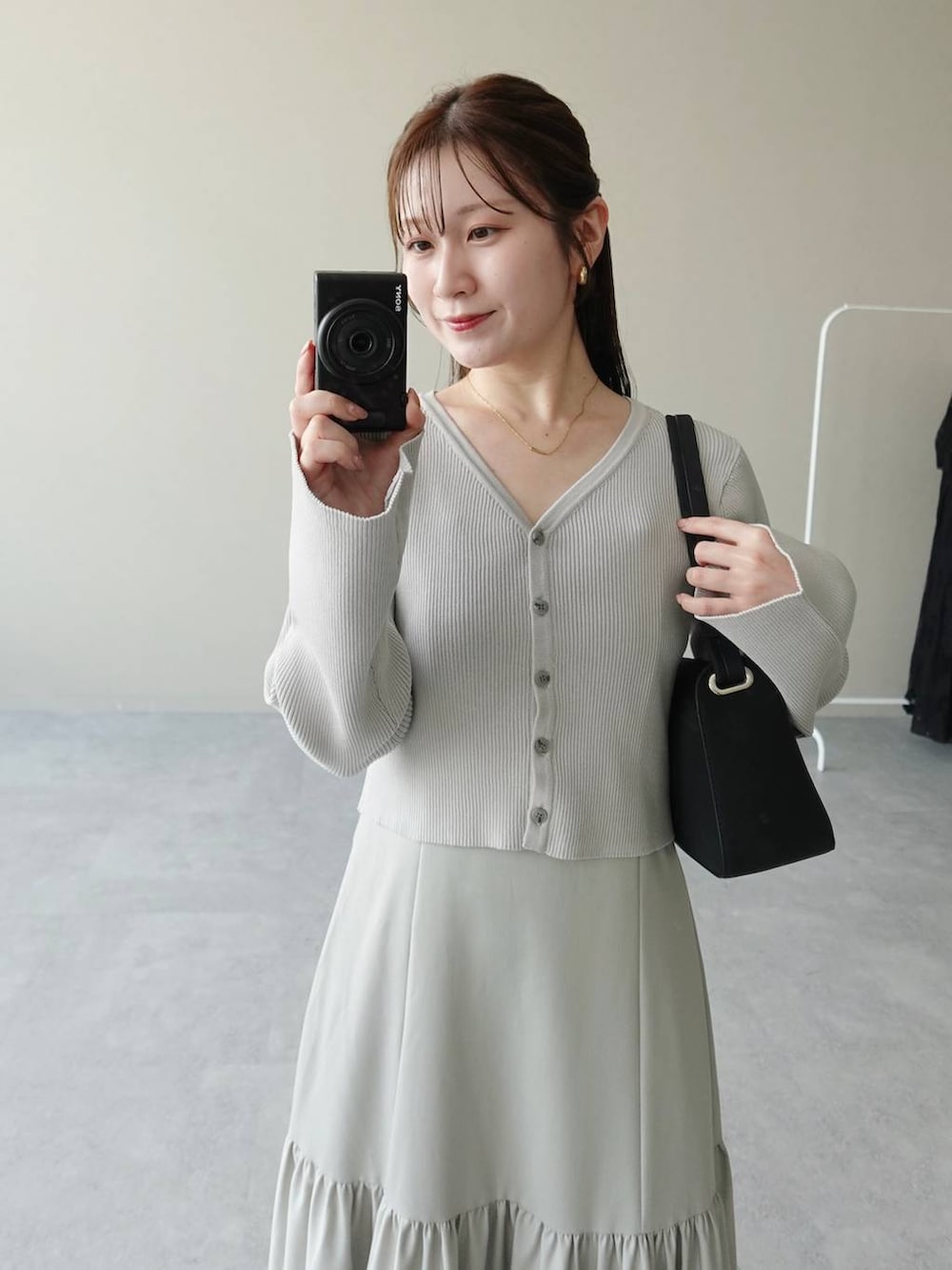 グレー系のワンピース、ブラック系のサンダル、ブラック系のショルダーバッグを着用したレディースの夏コーディネートの4枚目の写真