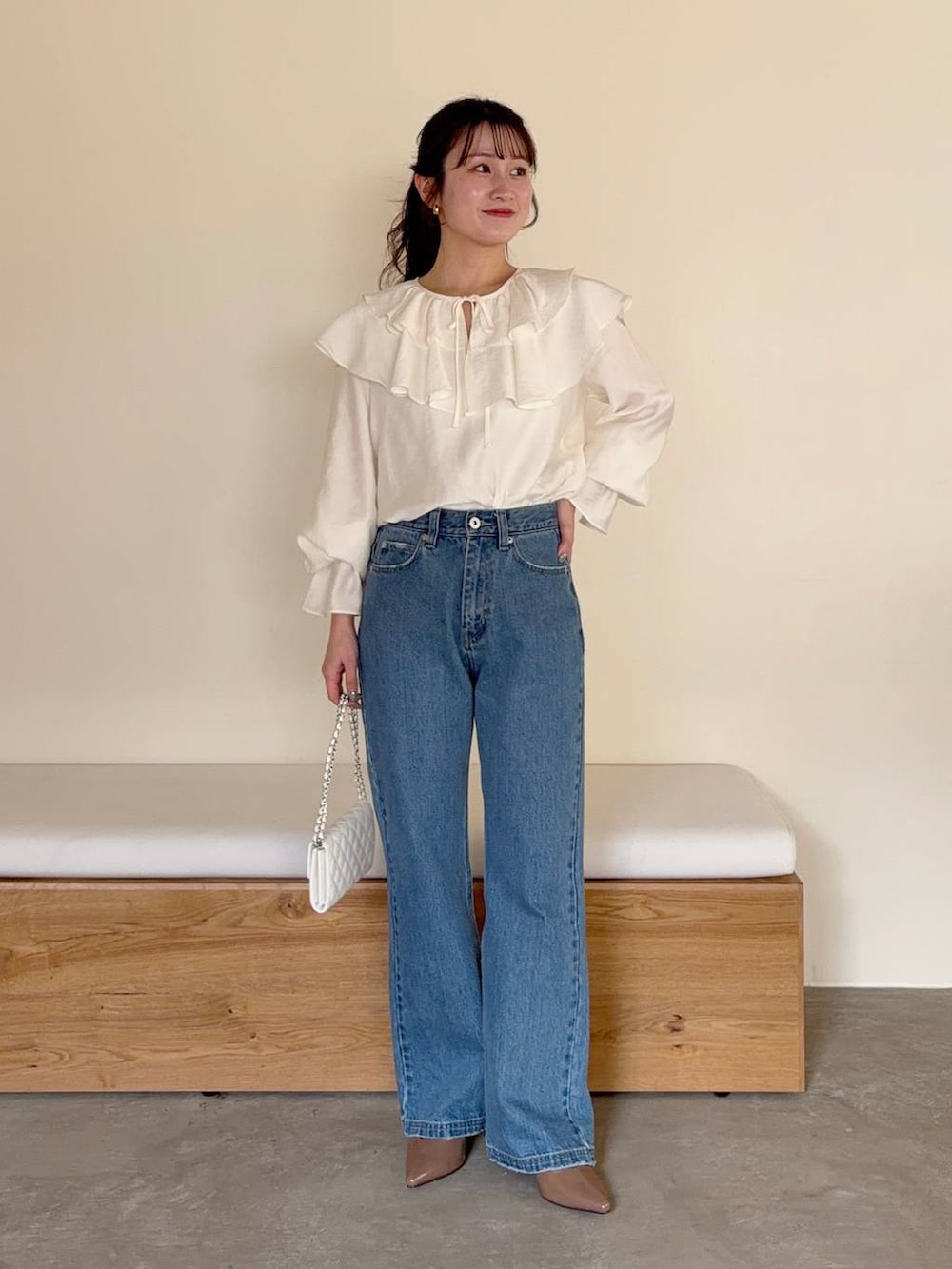 ブルー系のデニムパンツ、ホワイト系のシャツ/ブラウス、イエロー系のノーカラージャケットを着用したレディースの冬コーディネートの4枚目の写真