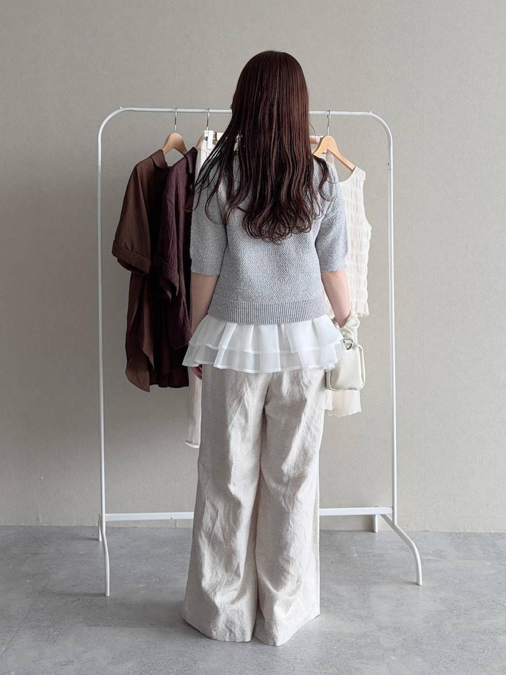 ブルー系のニット/セーター、グレー系のカーディガン/ボレロ、ベージュ系のその他パンツを着用したレディースの夏コーディネートの2枚目の写真
