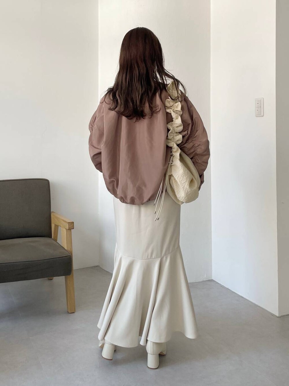 ホワイト系のハンドバッグ、ホワイト系のブーツ、ホワイト系のスカートを着用したレディースの秋コーディネートの2枚目の写真