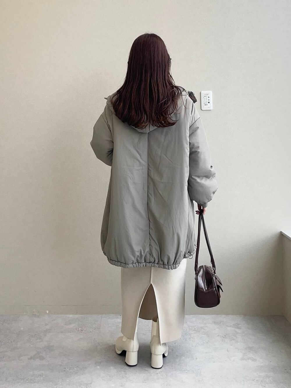 ホワイト系のブーツ、ホワイト系のニット/セーター、ホワイト系のスカートを着用したレディースの秋コーディネートの2枚目の写真