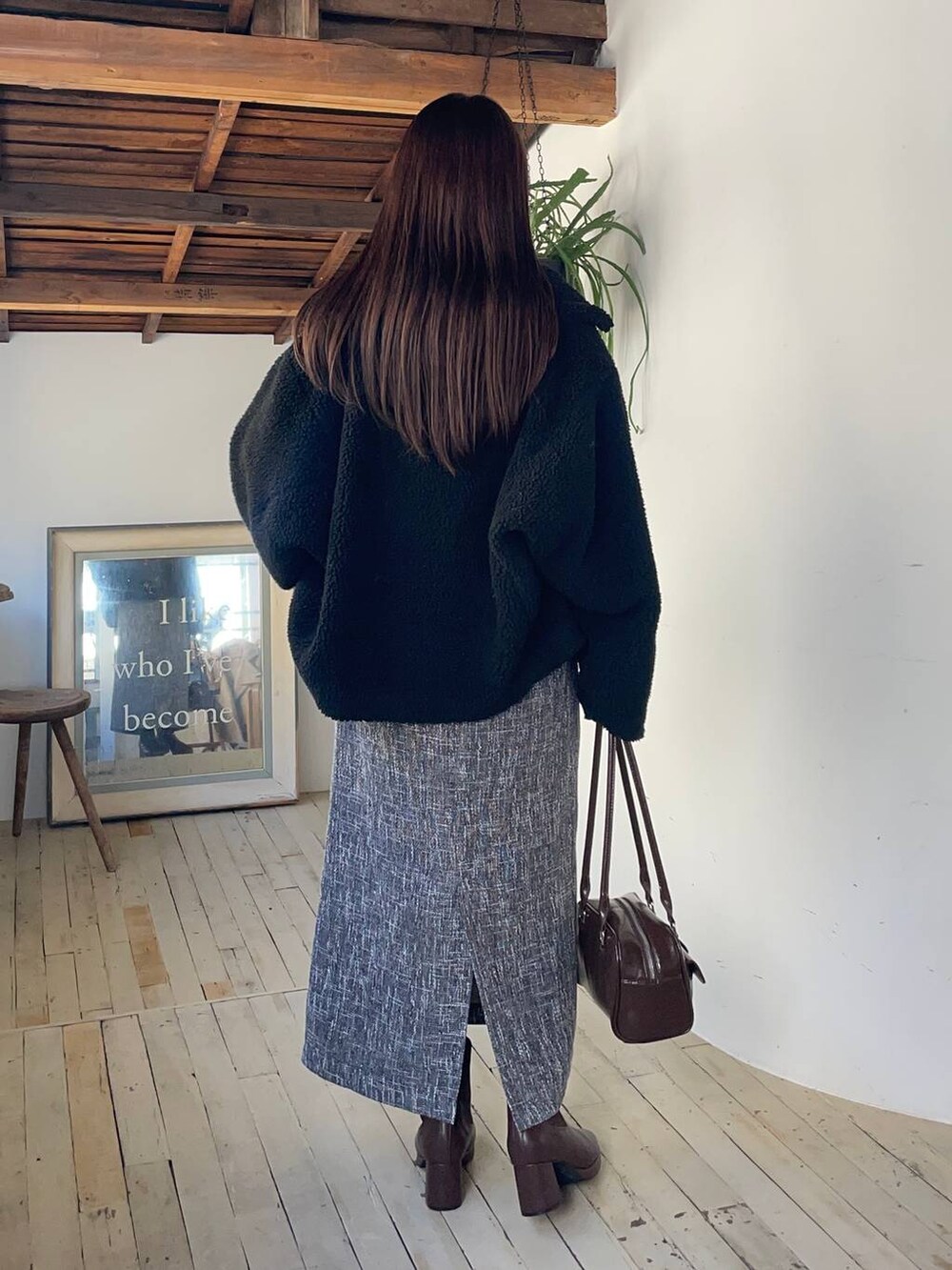 ブラック系のピーコート、ブラウン系のブーツ、レッド系のニット/セーターを着用したレディースの秋コーディネートの2枚目の写真