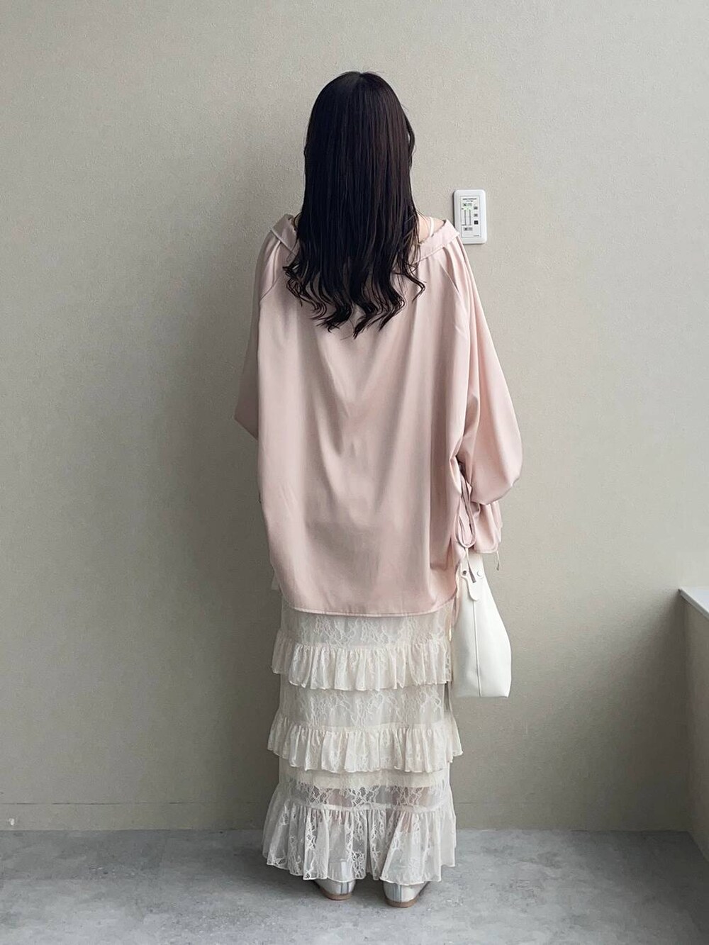 シルバー系のバレエシューズ、ホワイト系のスカート、ホワイト系のショルダーバッグを着用したレディースの春コーディネートの2枚目の写真