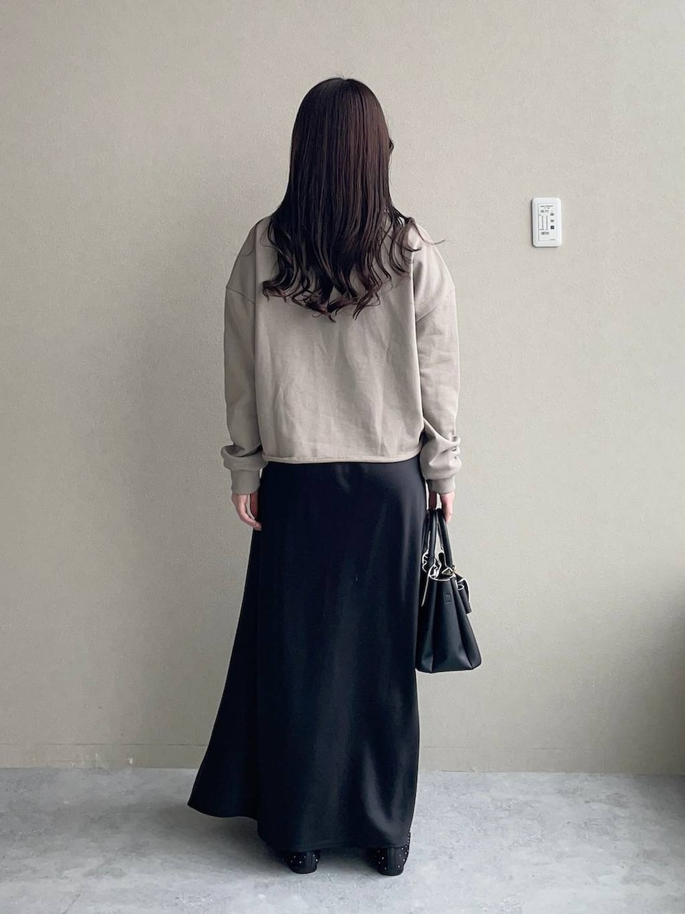 ブラック系のショルダーバッグ、ブラック系のバレエシューズ、ブラック系のスカートを着用したレディースの春コーディネートの2枚目の写真