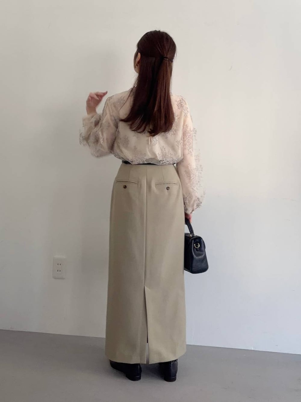 ブラック系のショルダーバッグ、ベージュ系のテーラードジャケット、ベージュ系のスカートを着用したレディースの冬コーディネートの4枚目の写真